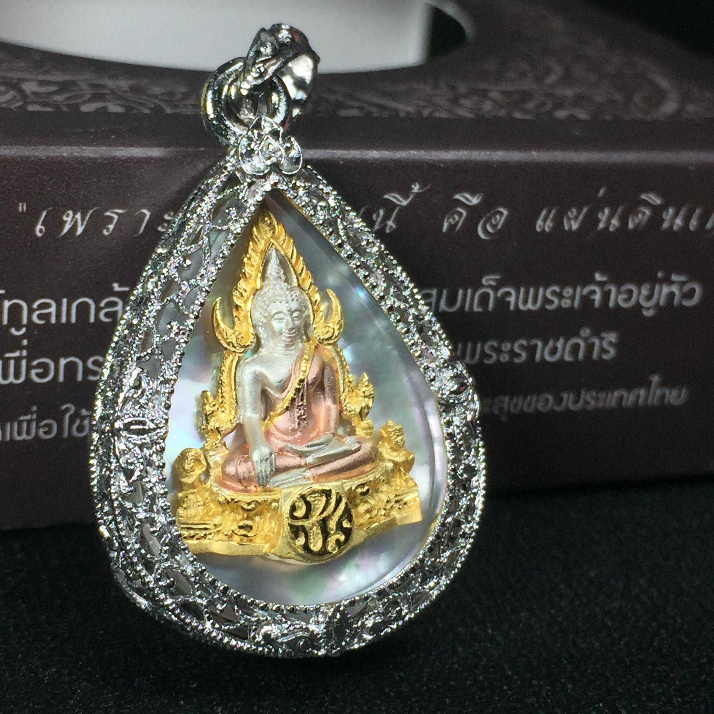 พระพุทธชินราช ภปร. โครงการ "เพราะแผ่นดินนี้ คือ แผ่นดินเกิด" ปี2548(รุ่นแรก) เหรียญทรงหยดน้ำ ขนาด 21 x 31 มม. เนื้อเงินสามกษัตริย์ องค์พระชุบสามกษัตริย์ ล้อมด้วยกรอบเงินชุบทองคำขาวสลักเสลาเป็นลวดลายละเอียดอ่อน ส่วนพื้นองค์พระเป็นเปลือกหอยมุข