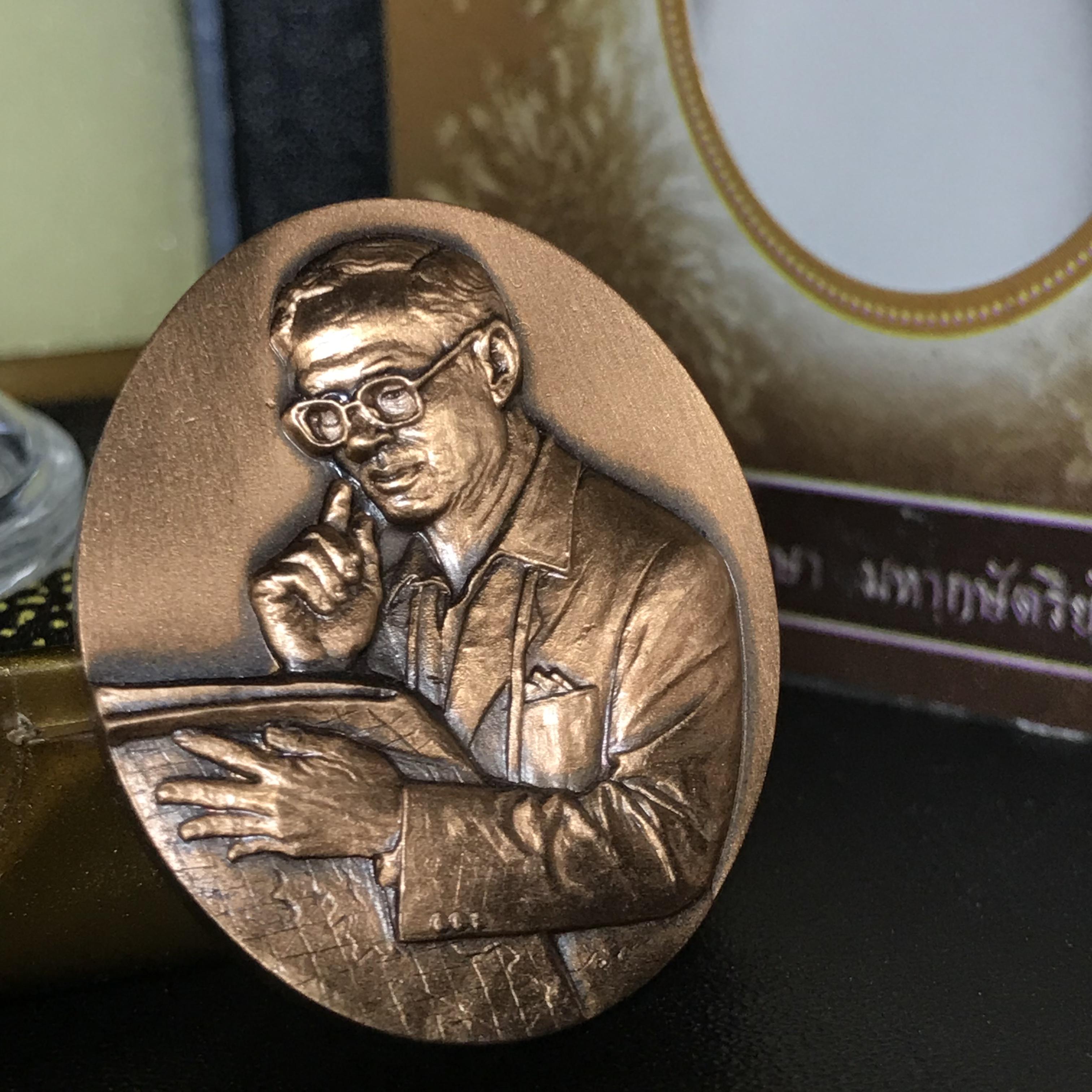 เหรียญรูปหล่อพระบาทสมเด็จพระเจ้าอยู่หัว ในหลวงทรงงาน “รุ่นเย็นศิระเพราะพระบริบาล 80พรรษา มหากษัตริย์คู่แผ่นดินสยาม” พ.ศ.2550 เนื้อทองแดงรมดำ(ขนาด 27*35 มม.)พร้อมกล่องบรรจุเดิมครบ