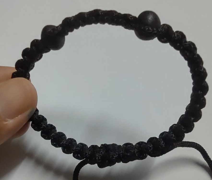 สร้อยข้อมือเชือกผ้าร่มสีดำ แบบร้อยเม็ดประคำแร่น้ำพี้ 2 เม็ด