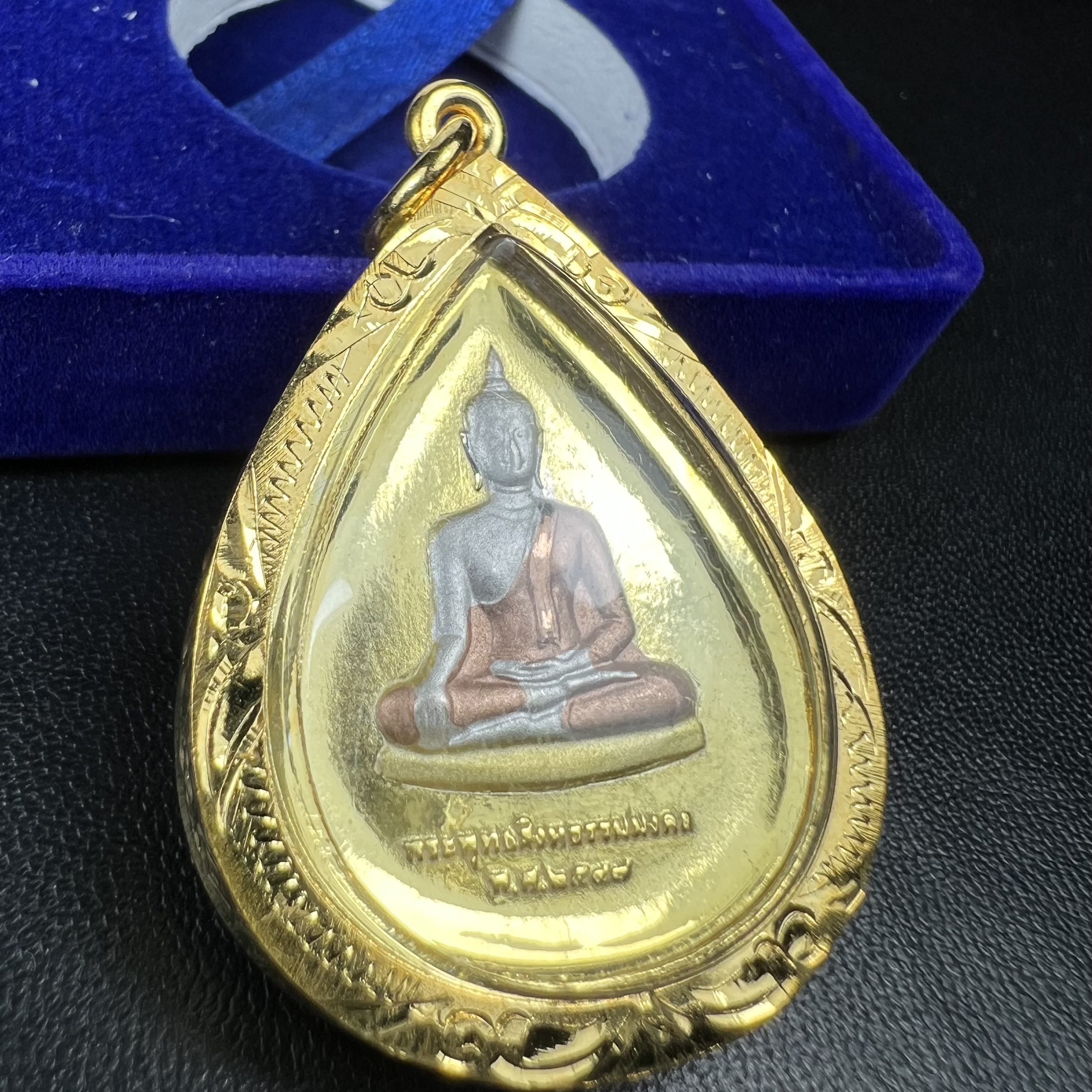 เหรียญพระพุทธสิงหธรรมมงคล ภปร. ปี 2547 ทรงหยดน้ำ ด้านหลังมี ภ.ป.ร. (ชนวนเก่า)เนื้อโลหะผสม ชุบทองสามกษัตริย์ สูง 3.3ซม.พิธีใหญ่ มวลสารดี ปลุกเสกวัดพระแก้ว(งานเลี่ยมกรอบเดิมจากผู้จัดสร้างห่อหุ้มด้วยทองนพเกล้า)