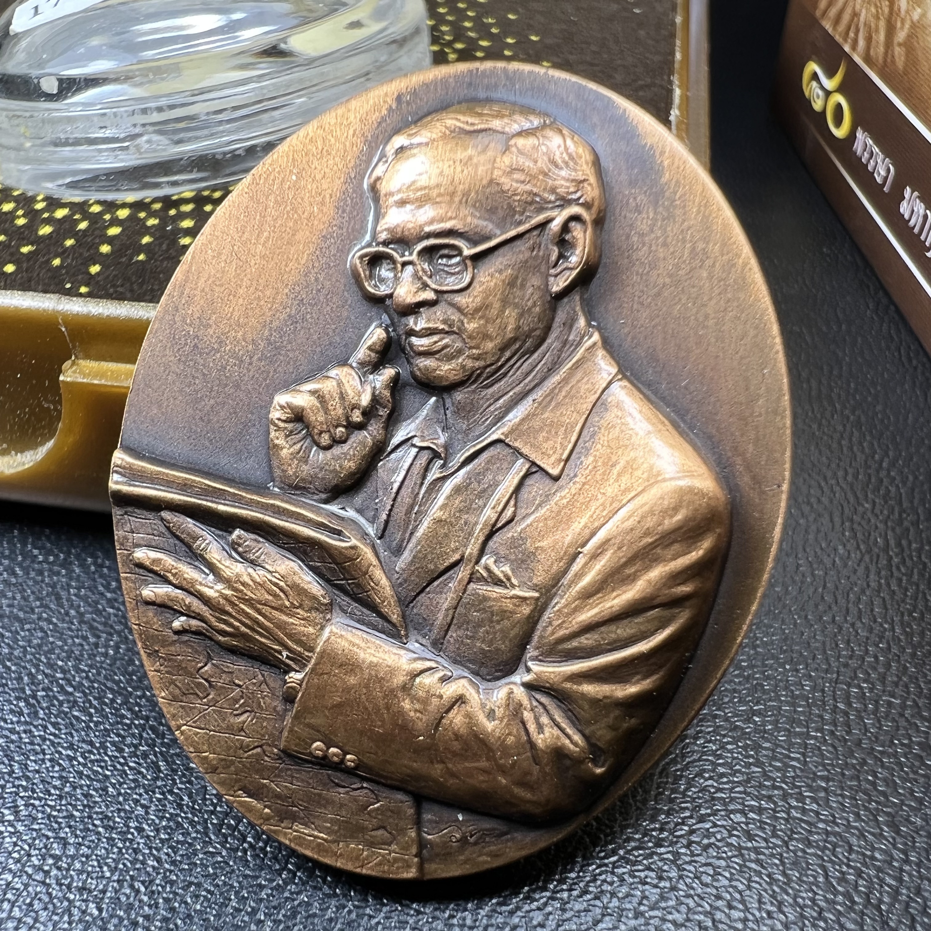 เหรียญรูปหล่อพระบาทสมเด็จพระเจ้าอยู่หัว ในหลวงทรงงาน “รุ่นเย็นศิระเพราะพระบริบาล 80พรรษา มหากษัตริย์คู่แผ่นดินสยาม” พ.ศ.2550 เนื้อทองแดงรมดำ(ขนาด 27*35 มม.)พร้อมกล่องบรรจุเดิมครบ