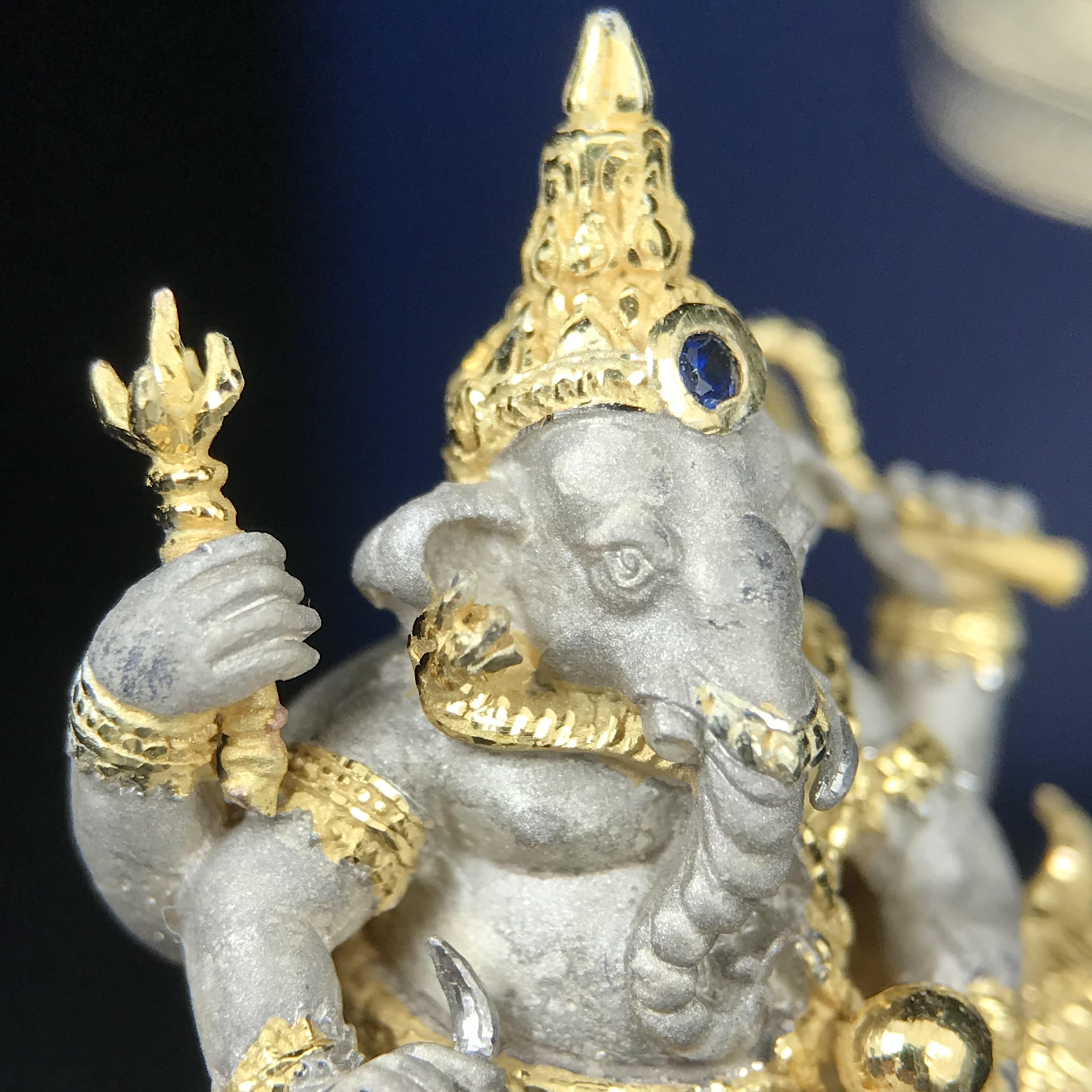 พระพิฆเนศ เทวสถานโบสถ์พราหมณ์ ปี 2539 รูปหล่อลอยองค์พระพิฆเณศวร เนื้อเงินสามกษัตริย์ ฝังพลอยน้ำเงิน(พ่นทรายขัดเงาบางส่วน) พิมพ์ใหญ่ขนาดประมาณ 1.8 * 2.5 ซม. ผลิตโดย บ.แพรนด้า จิวเวลรี่( พิธีใหญ่ พุทธศิลป์งดงาม)อีกหนึ่งรุ่นยอดนิยม (1 ใน 4999 องค์)หายาก