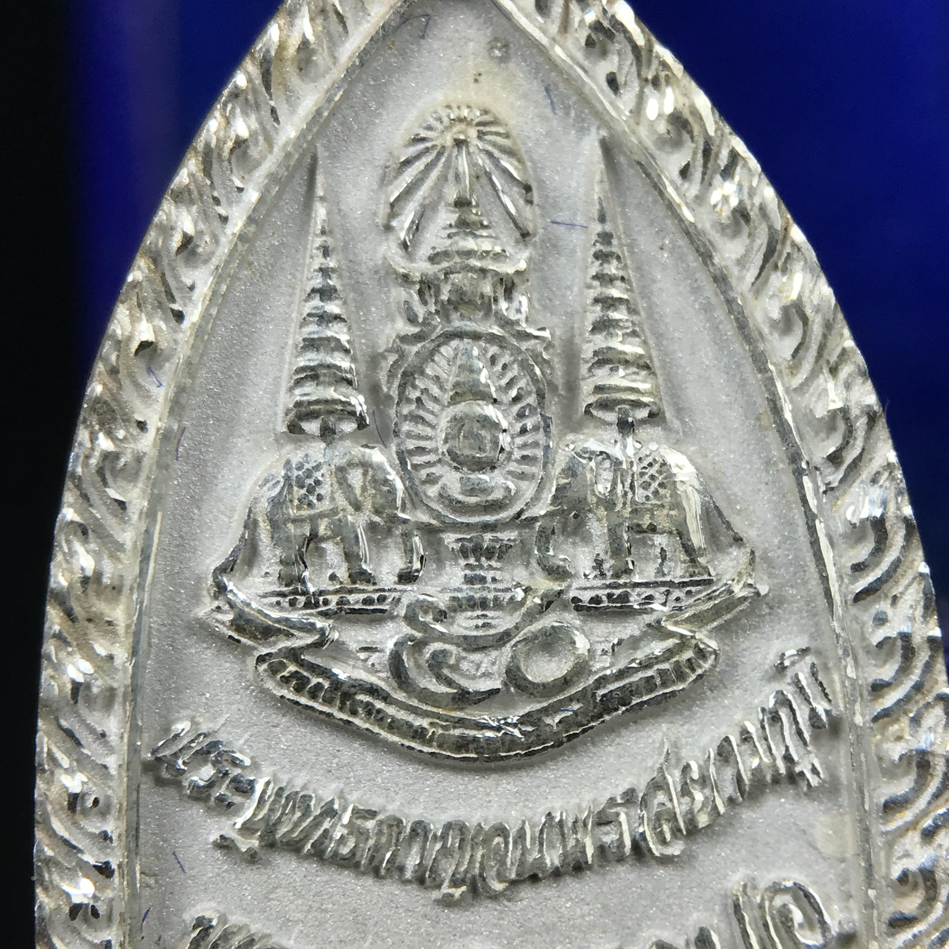 พระพุทธกาญจนพรสยามภูมิ ภปร. ปี 2539 เนื้อเงินพื้นทรายประกาย(ผิวเดิมสวย) พิมพ์ทรงใบขนุน ขนาด3.2ซม. พระพุทธรูปประจำพระชนมวาร รัชกาลที่9 ทรงโปรดเกล้าให้วิทยาลัยป้องกันราชอาณาจักร(วปอ.)สร้างในวโรกาสทรงครองสิริราชสมบัติครบ50ปี พ.ศ.2539(1ใน5000องค์)