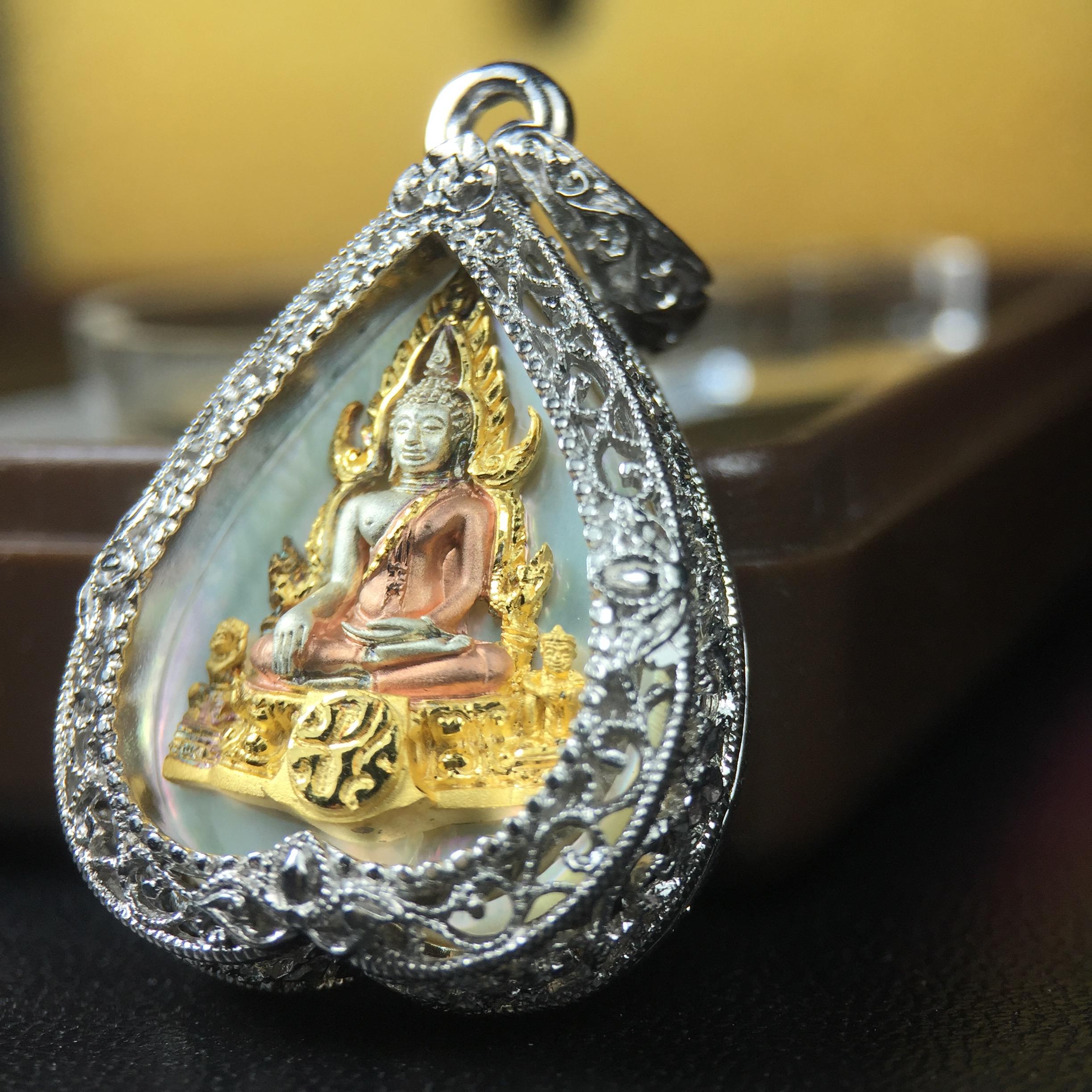 พระพุทธชินราช ภปร. โครงการ "เพราะแผ่นดินนี้ คือ แผ่นดินเกิด" ปี2548(รุ่นแรก) เหรียญทรงใบโพธิ์ ขนาด 21 x 29 มม. เนื้อเงินสามกษัตริย์ องค์พระชุบสามกษัตริย์ ล้อมด้วยกรอบเงินชุบทองคำขาวสลักเสลาเป็นลวดลายละเอียดอ่อน ส่วนพื้นองค์พระเป็นเปลือกหอยมุข