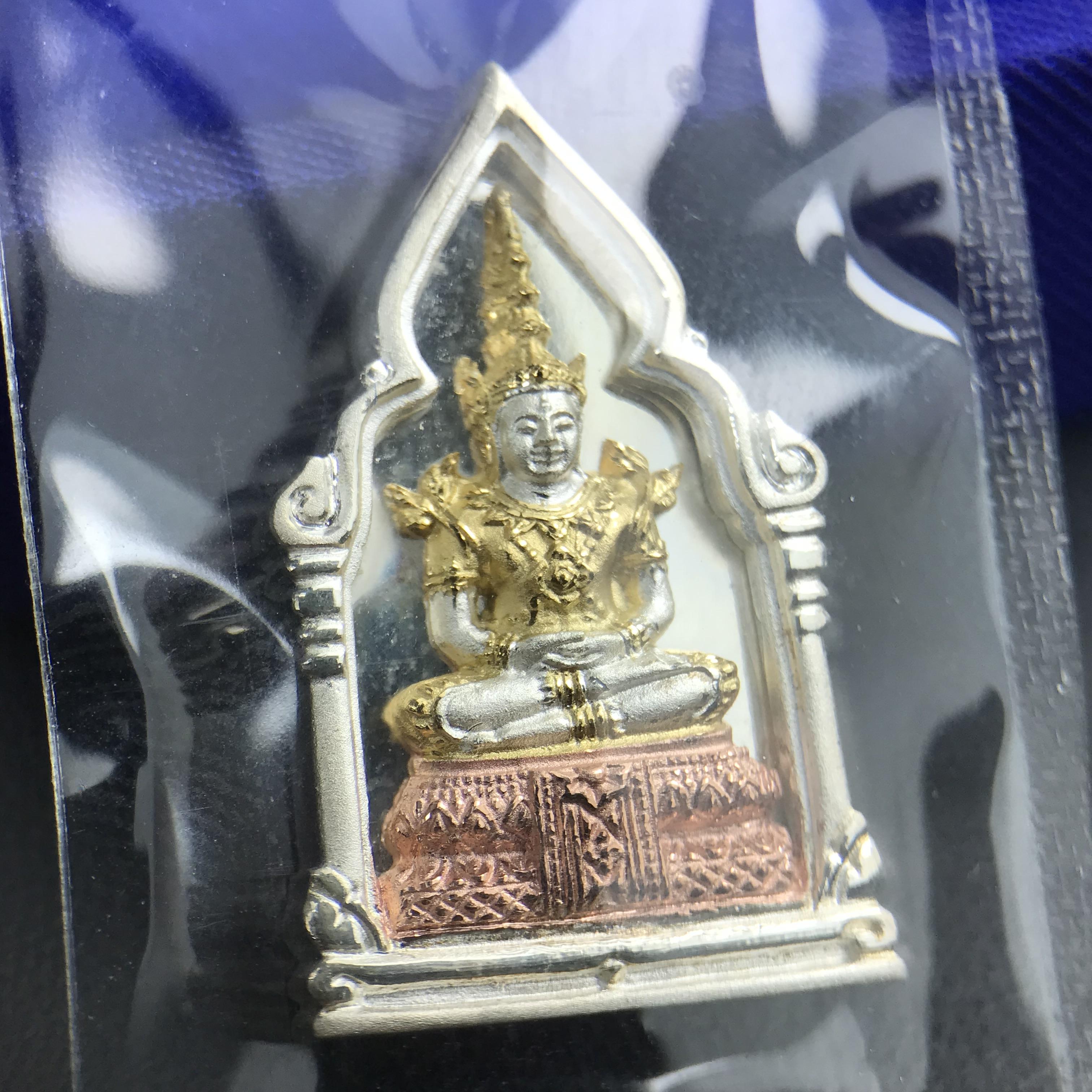 พระพุทธมหามณีรัตนปฎิมากร(พระแก้วมรกต)รุ่น เฉลิมพระเกียรติ วัดพระศรีรัตนศาสดารามราม(วัดพระแก้ว) ปี2543 เนื้อเงินสามกษัตริย์พิมพ์ซุ้มกนกเล็ก ขนาด สูง 2.5 ซ.ม. สภาพสวยซีนเดิมกล่องครบ(องค์หมายเลข ๘๗๙)