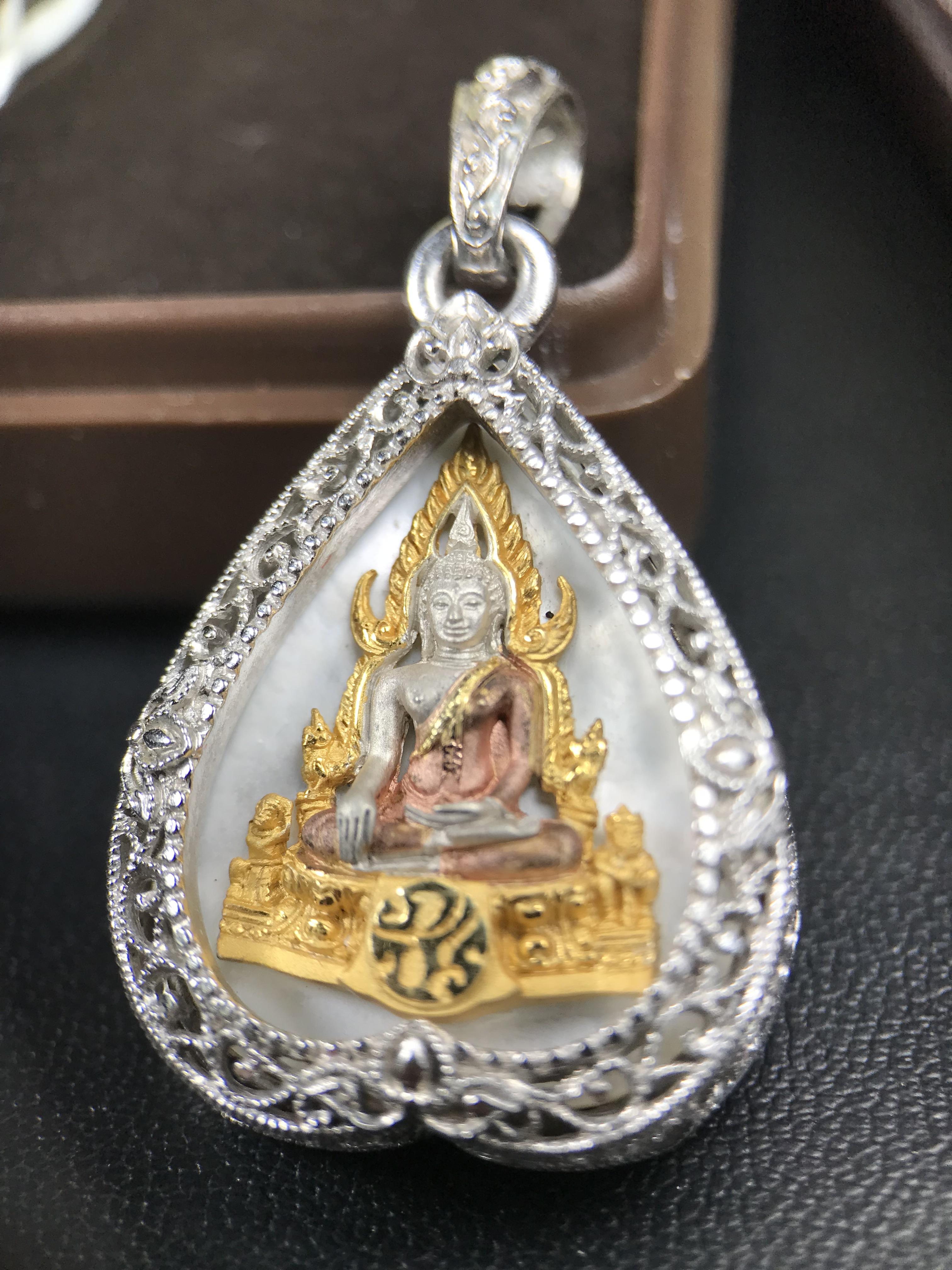 พระพุทธชินราช ภปร. โครงการ "เพราะแผ่นดินนี้ คือ แผ่นดินเกิด" ปี 2548(รุ่นแรก) เหรียญทรงใบโพธิ์ ขนาด 21 x 29 มม. เนื้อเงินสามกษัตริย์ องค์พระชุบสามกษัตริย์ ล้อมด้วยกรอบเงินชุบทองคำขาวสลักเสลาเป็นลวดลายละเอียดอ่อน ส่วนพื้นองค์พระเป็นเปลือกหอยมุข