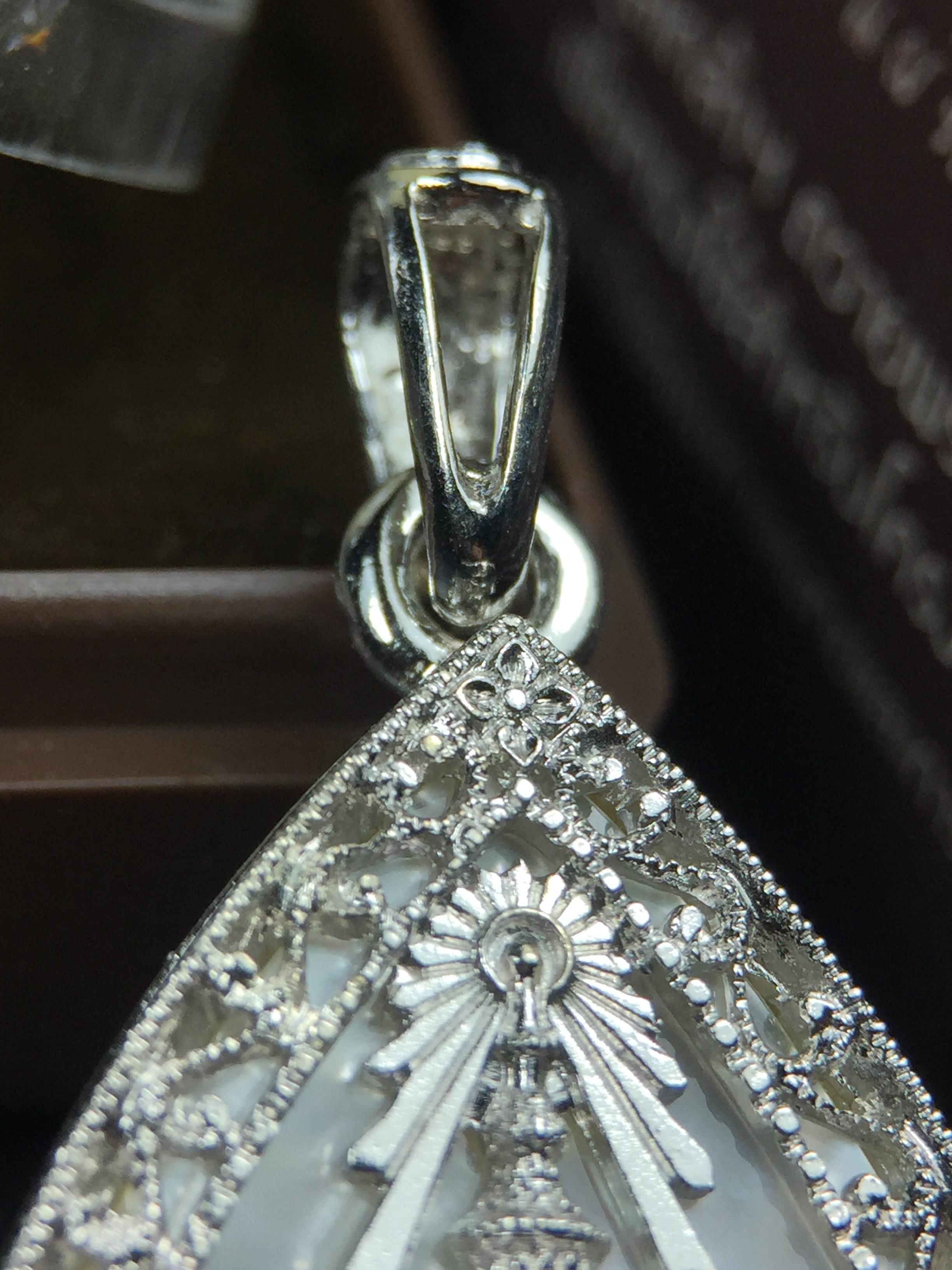 พระพุทธชินราช ภปร. โครงการ "เพราะแผ่นดินนี้ คือ แผ่นดินเกิด" ปี2548(รุ่นแรก) เหรียญทรงหยดน้ำ ขนาด 21 x 31 มม. เนื้อเงินสามกษัตริย์ องค์พระชุบสามกษัตริย์ ล้อมด้วยกรอบเงินชุบทองคำขาวสลักเสลาเป็นลวดลายละเอียดอ่อน ส่วนพื้นองค์พระเป็นเปลือกหอยมุข