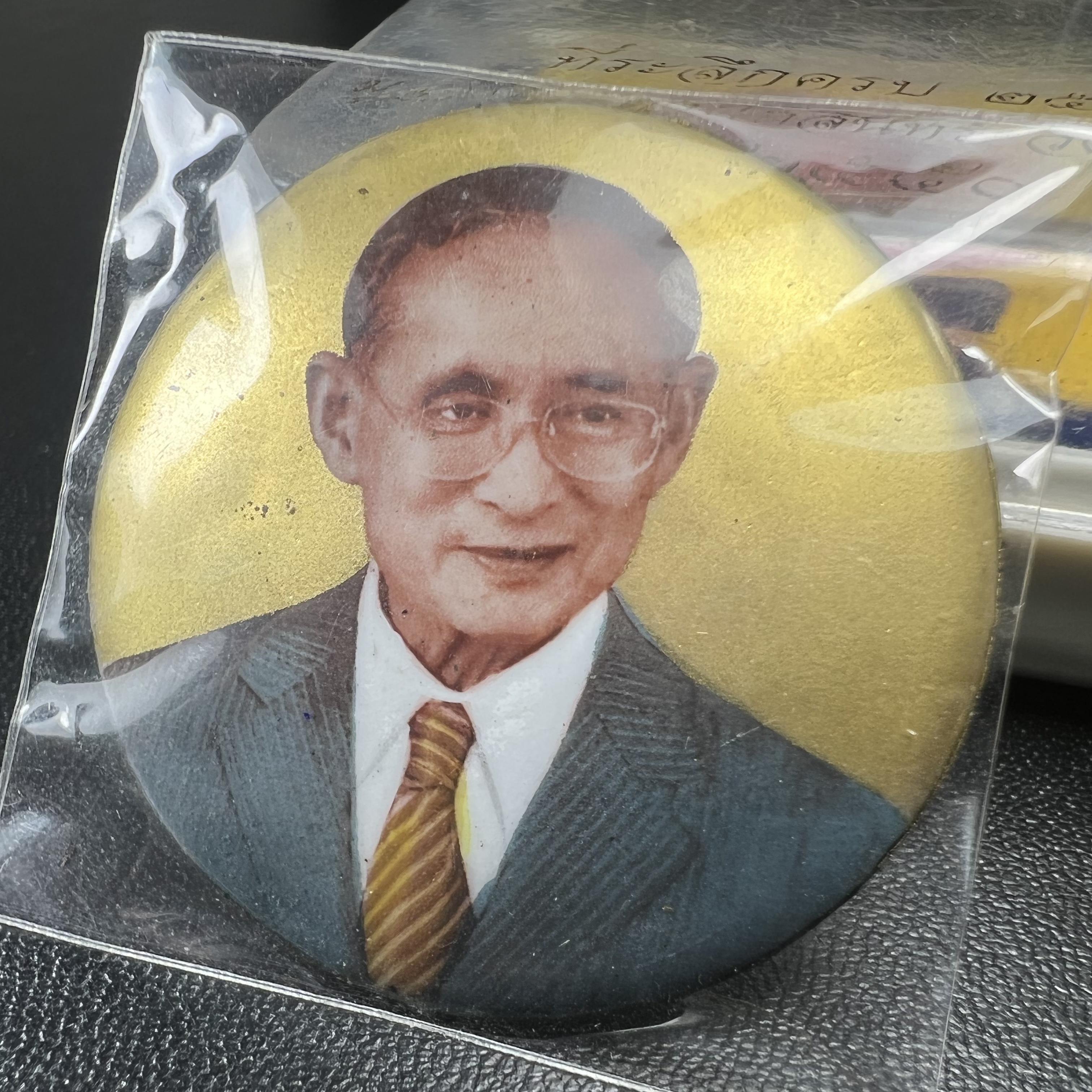 ล็อกเกตในหลวงรัชกาลที่9 ที่ระลึกครบ 25 ปี มูลนิธิศรีรัตนโกสินทร์ วัดสุทธาราม พ.ศ. 2550 พิมพ์ทรงกลมฉากสีทอง หลังปิดแผ่นโลหะสีขาว(สแตนเลส)ฝังพระยอดธง(นิยม)