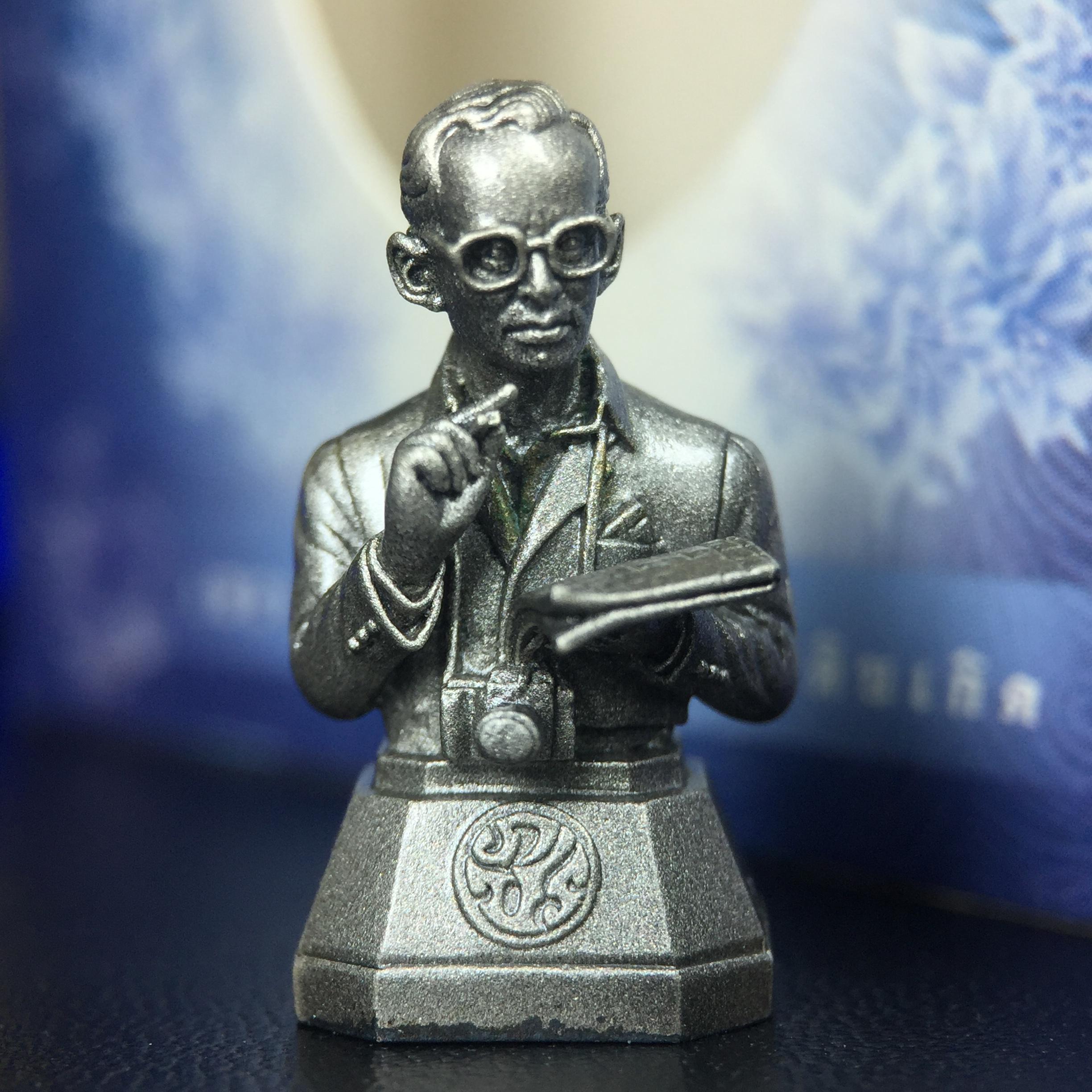 พระบรมรูปพระบาทสมเด็จพระเจ้าอยู่หัวรัชกาลที่ 9(ทรงงาน) ภปร. รุ่นเพราะแผ่นดินนี้คือแผ่นดินเกิด ปี 2551 ขนาดสูง 1 นิ้ว เนื้อบรอนซ์ชุบเงินรมดำ(ด้านหน้า ฐานพระบรมรูปฯ ประดิษฐานอักษรพระปรมาภิไธย ภ.ป.ร.)นิยมหายาก