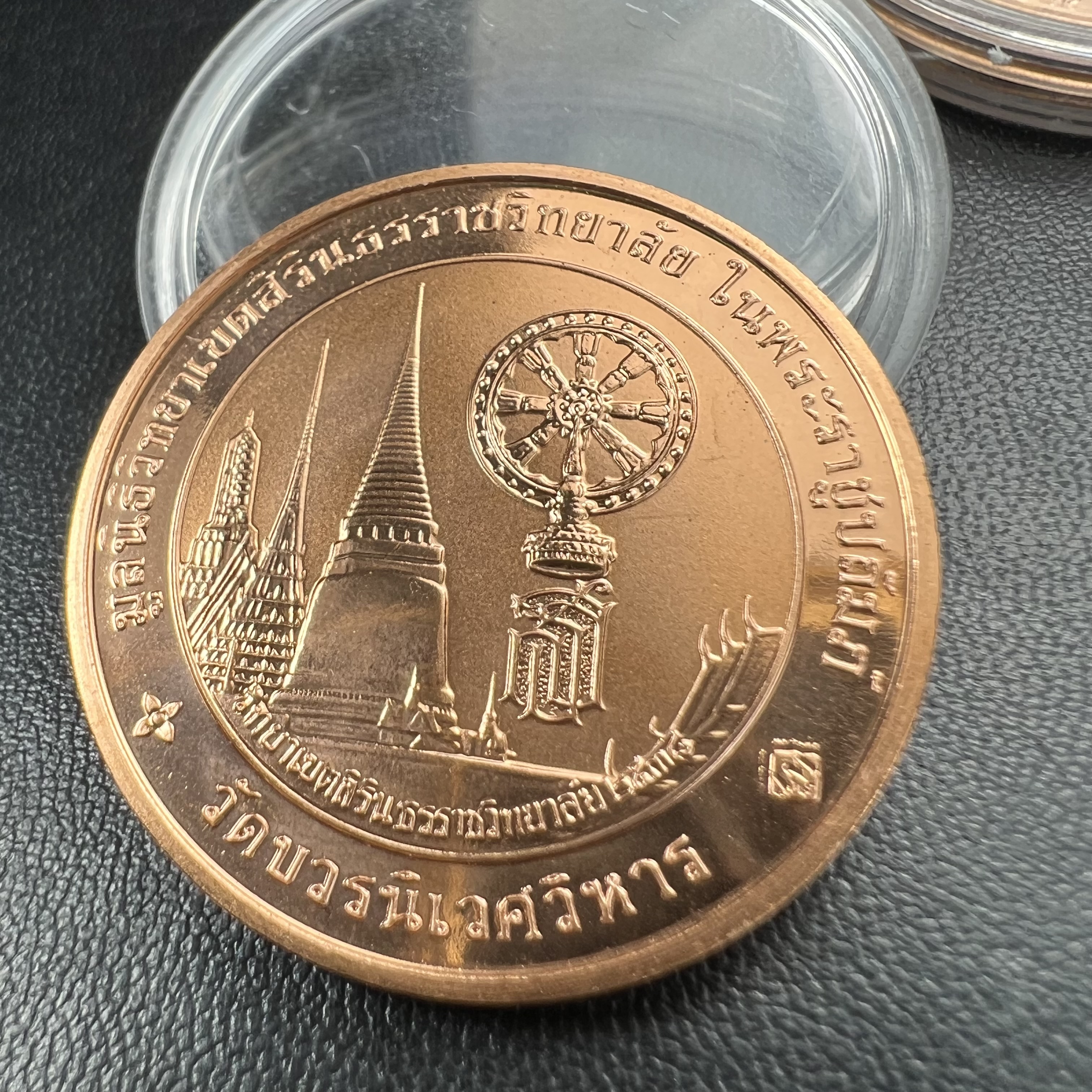 เหรียญพระแก้วมรกต ทรงเครื่องฤดูหนาว หลัง สธ.รุ่นเฉลิมพระเกียรติ ออกโดยมูลนิธิวิทยาเขตสิรินธรราชวิทยาลัย ในพระบรมราชูปถัมภ์ วัดบวรนิเวศวิหาร ปี 2538 เนื้อทองแดงบริสุทธิ์ 99.50% ขัดเงาสามมิติ ขนาด 3.2 ซม.ผลิตโดยโรงกษาปณ์ POB JOY MINT LTD.UK ประเทศอังกฤษ(เหร