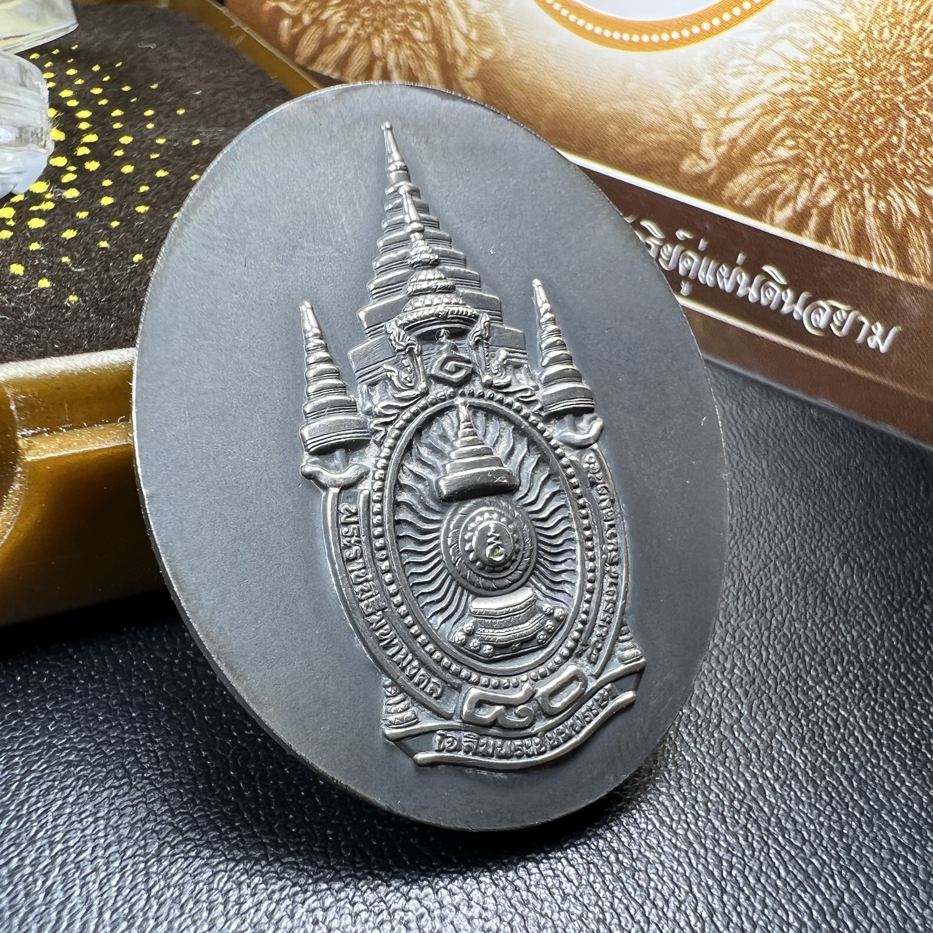 เหรียญรูปหล่อพระบาทสมเด็จพระเจ้าอยู่หัว ในหลวงทรงงาน “รุ่นเย็นศิระเพราะพระบริบาล 80พรรษา มหากษัตริย์คู่แผ่นดินสยาม” พ.ศ.2550 เนื้อเงินรมดำ(ขนาด 27*35 มม.) พร้อมกล่องบรรจุเดิมครบ