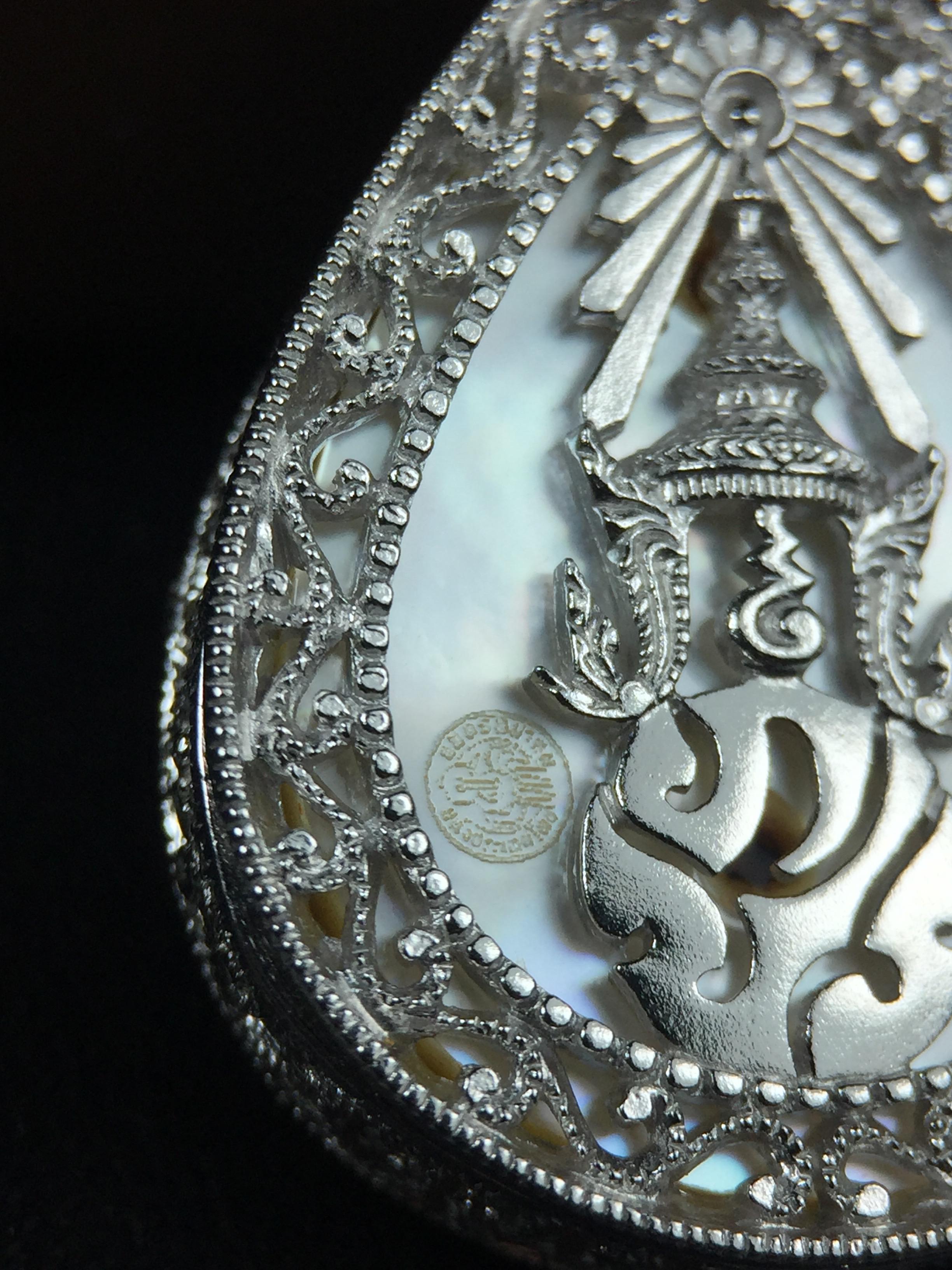 พระพุทธชินราช ภปร. โครงการ "เพราะแผ่นดินนี้ คือ แผ่นดินเกิด" ปี2548(รุ่นแรก) เหรียญทรงหยดน้ำ ขนาด 21 x 31 มม. เนื้อเงินสามกษัตริย์ องค์พระชุบสามกษัตริย์ ล้อมด้วยกรอบเงินชุบทองคำขาวสลักเสลาเป็นลวดลายละเอียดอ่อน ส่วนพื้นองค์พระเป็นเปลือกหอยมุข