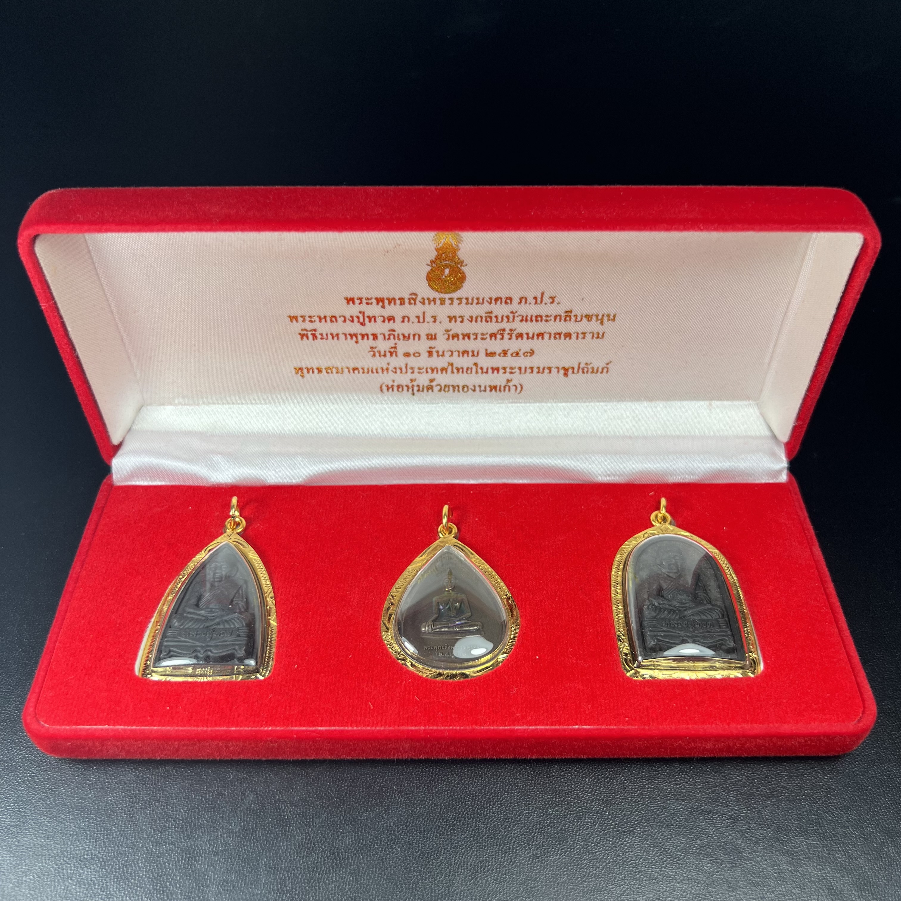 พระชุดของขวัญ 3 องค์ พระหลวงปู่ทวด ภปร. ทรงกลีบบัวและกลีบขนุนพร้อมเหรียญพระพุทธสิงหธรรมมงคล ปี 2547 (ชนวนเก่า)เนื้อว่านด้านหลังมี ภปร. เป็นโลหะผสมสูง 3.3ซม.พิธีใหญ่ มวลสารดี ปลุกเสกวัดพระแก้ว(งานเลี่ยมกรอบเดิมจากผู้จัดสร้างห่อหุ้มด้วยทองนพเกล้า)