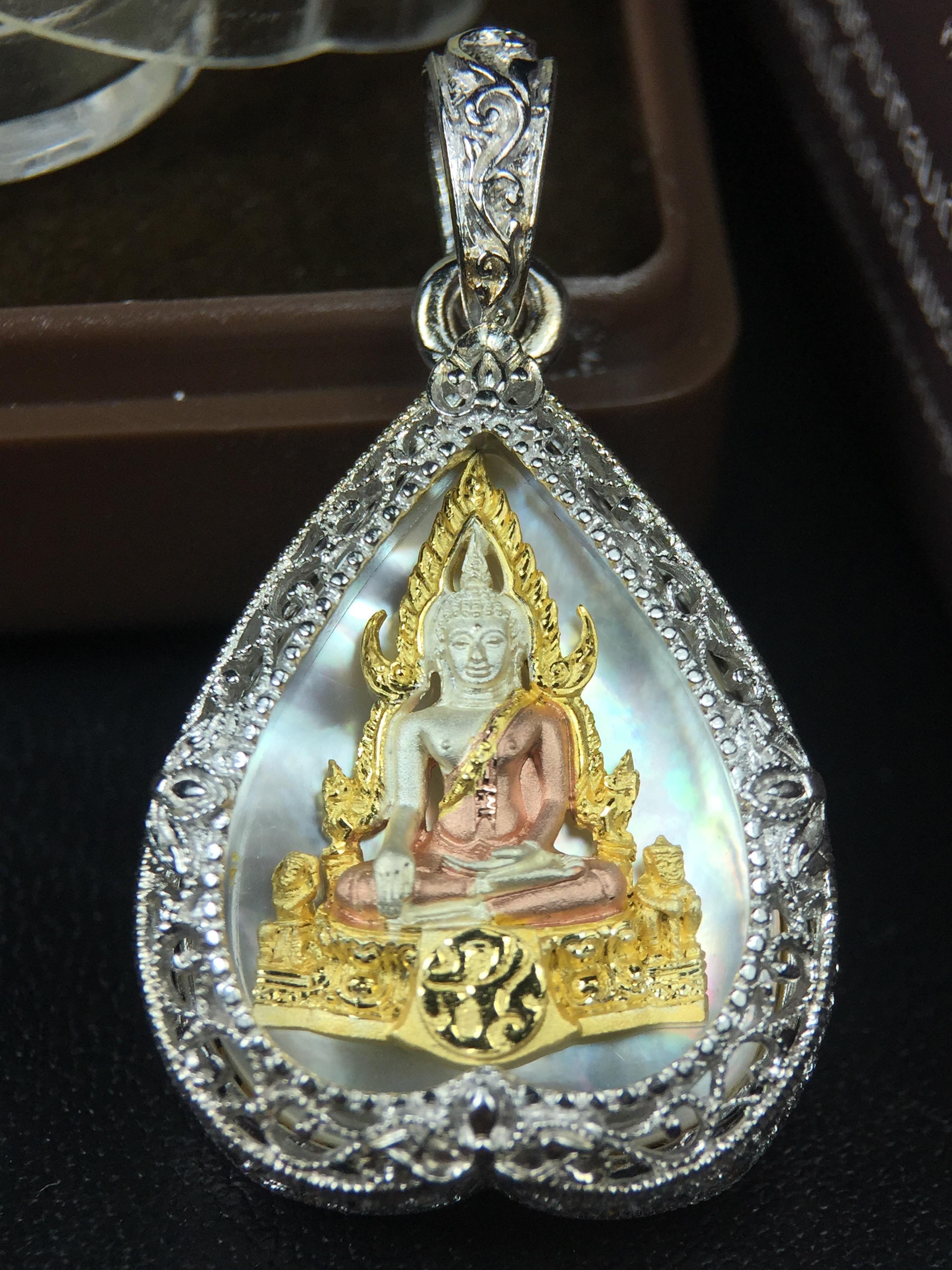 พระพุทธชินราช ภปร. โครงการ "เพราะแผ่นดินนี้ คือ แผ่นดินเกิด" ปี2548(รุ่นแรก) เหรียญทรงใบโพธิ์ ขนาด 21 x 29 มม. เนื้อเงินสามกษัตริย์ องค์พระชุบสามกษัตริย์ ล้อมด้วยกรอบเงินชุบทองคำขาวสลักเสลาเป็นลวดลายละเอียดอ่อน ส่วนพื้นองค์พระเป็นเปลือกหอยมุข