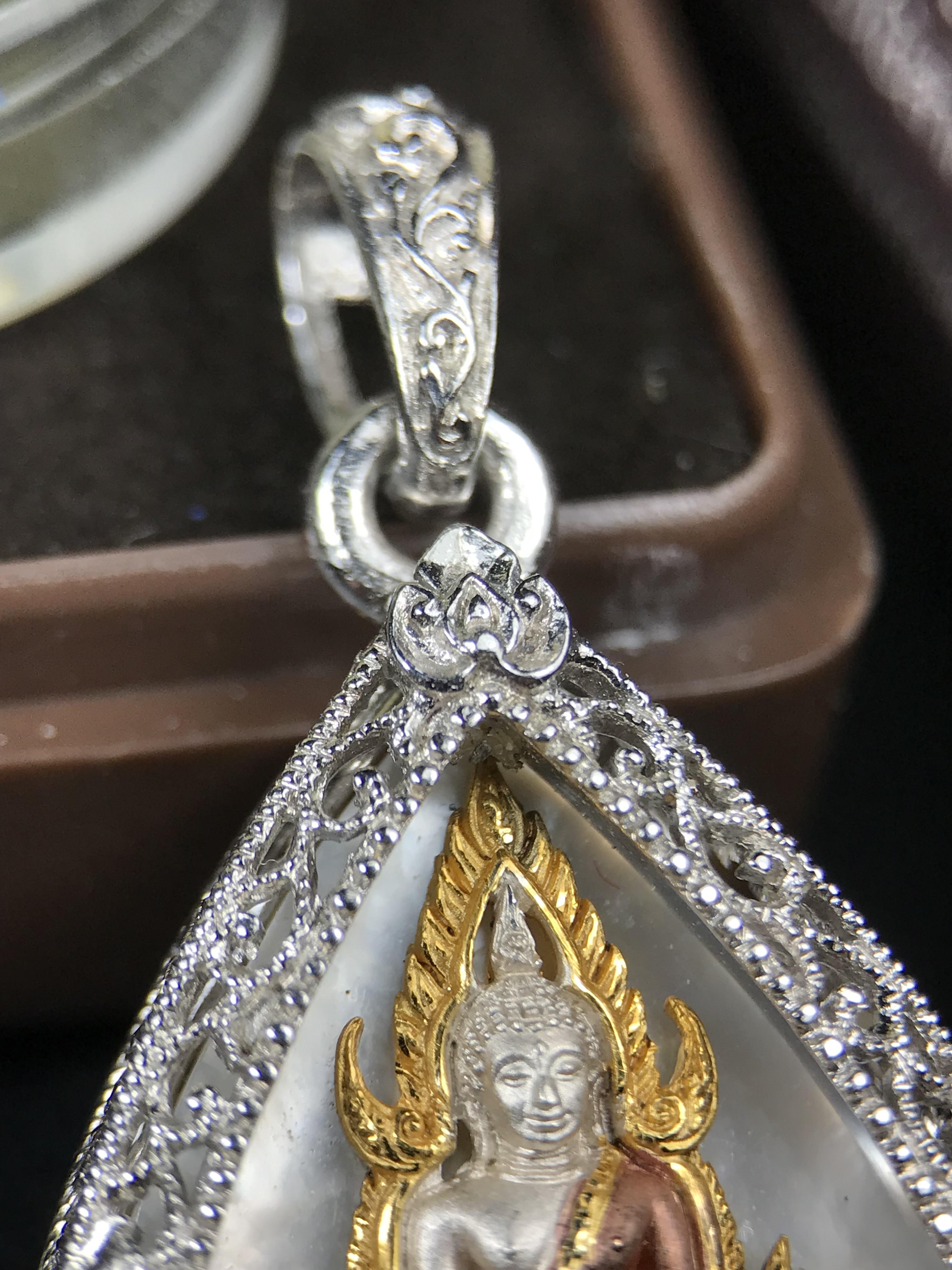 พระพุทธชินราช ภปร. โครงการ "เพราะแผ่นดินนี้ คือ แผ่นดินเกิด" ปี 2548(รุ่นแรก) เหรียญทรงหยดน้ำ ขนาด 21 x 31 มม. เนื้อเงินสามกษัตริย์ องค์พระชุบสามกษัตริย์ ล้อมด้วยกรอบเงินชุบทองคำขาวสลักเสลาเป็นลวดลายละเอียดอ่อน ส่วนพื้นองค์พระเป็นเปลือกหอยมุข