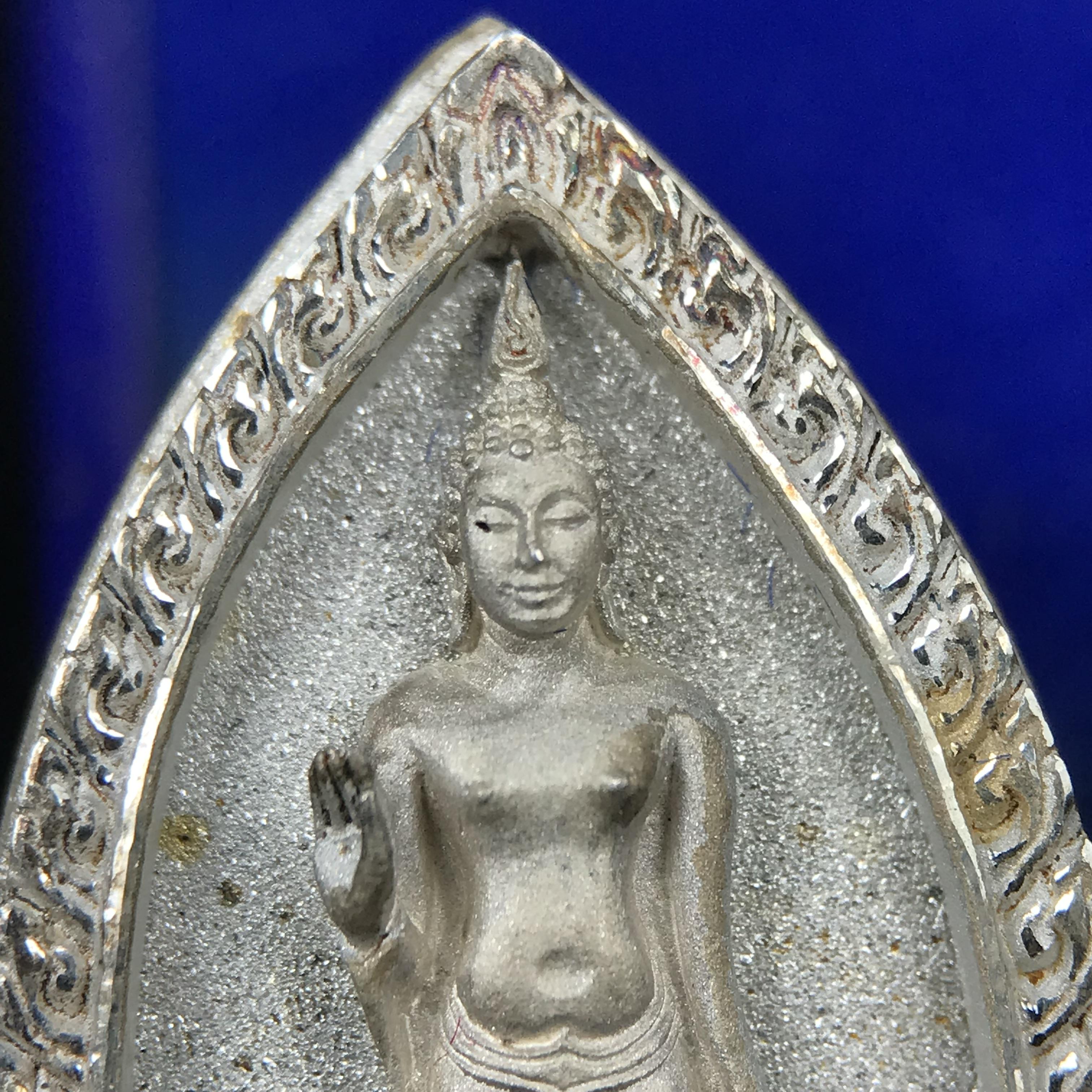 พระพุทธกาญจนพรสยามภูมิ ภปร. ปี 2539 เนื้อเงินพื้นทรายประกาย(ผิวเดิมสวย) พิมพ์ทรงใบขนุน ขนาด3.2ซม. พระพุทธรูปประจำพระชนมวาร รัชกาลที่9 ทรงโปรดเกล้าให้วิทยาลัยป้องกันราชอาณาจักร(วปอ.)สร้างในวโรกาสทรงครองสิริราชสมบัติครบ50ปี พ.ศ.2539(1ใน5000องค์)