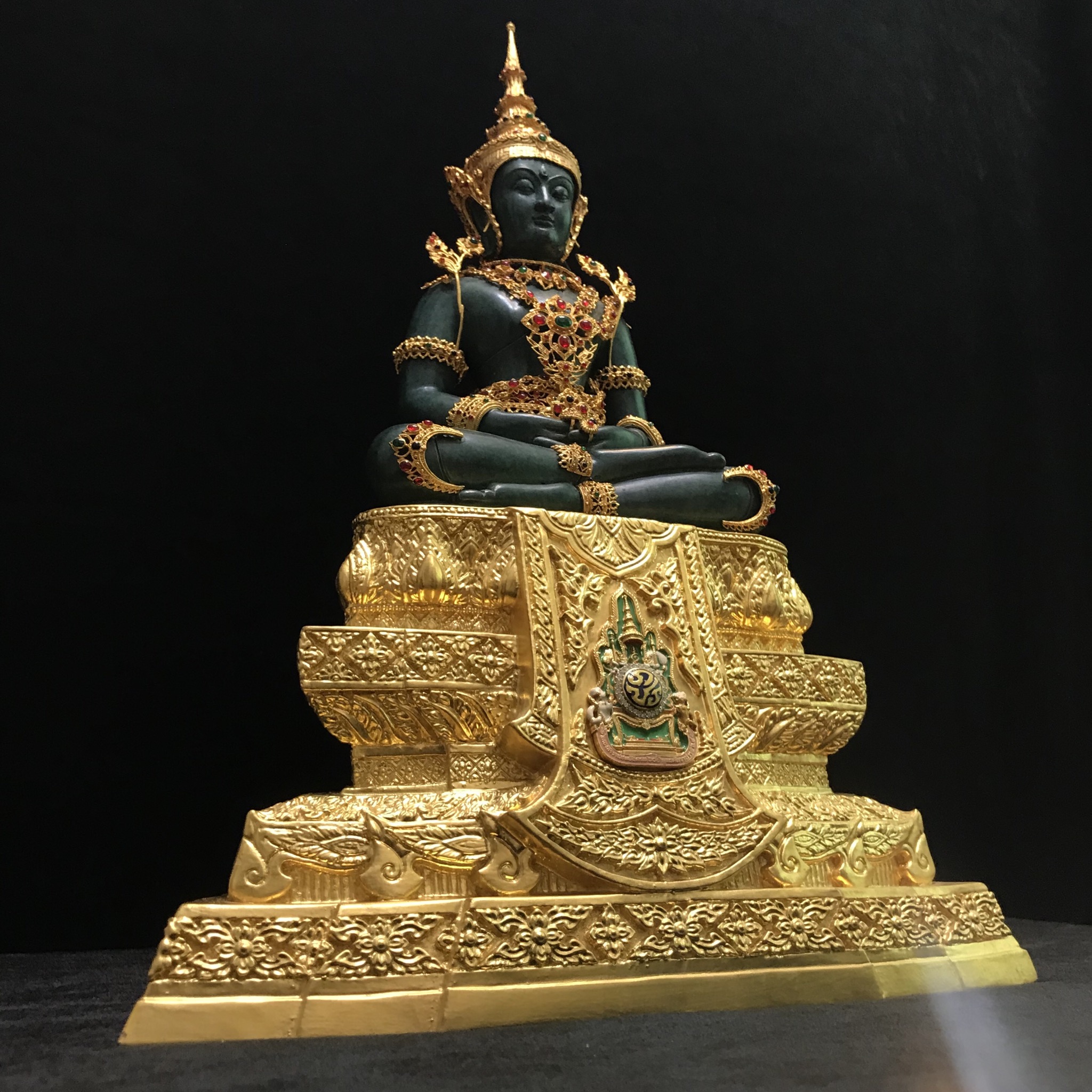 พระแก้วมรกต(จำลอง)ลอยองค์ ขนาดหน้าตัก 5 นิ้ว ทรงเครื่องฤดูร้อน เนื้อโลหะเคลือบสีเขียว เครื่องทรงชุบทองลงยาสี ฐานเนื้อโลหะ ลงรักปิดทองคำ ประดิษฐานตราสัญลักษณ์ฉลองสิริราชสมบัติ ครบ 60 ปี