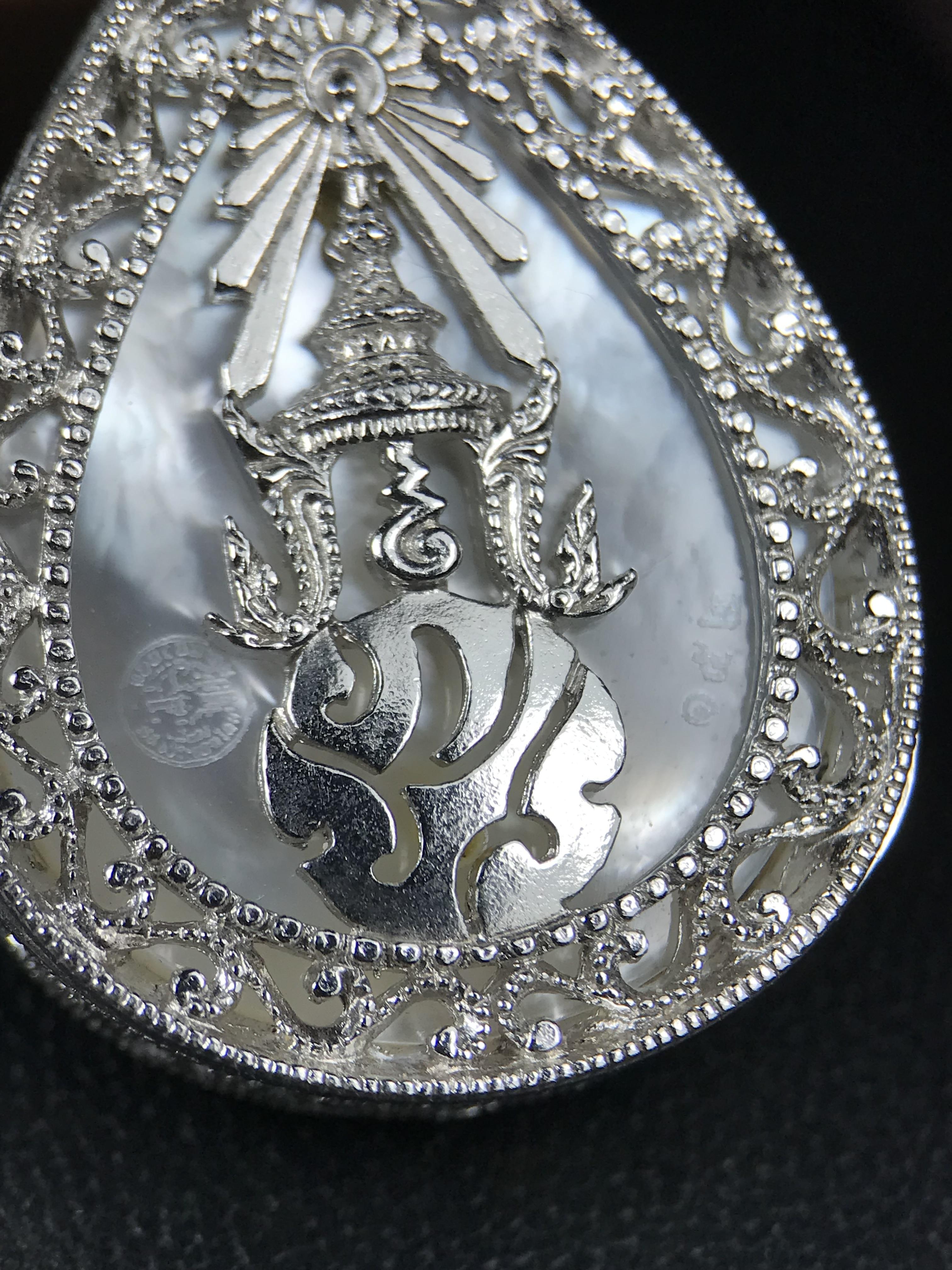 พระพุทธชินราช ภปร. โครงการ "เพราะแผ่นดินนี้ คือ แผ่นดินเกิด" ปี 2548(รุ่นแรก) เหรียญทรงหยดน้ำ ขนาด 21 x 31 มม. เนื้อเงินสามกษัตริย์ องค์พระชุบสามกษัตริย์ ล้อมด้วยกรอบเงินชุบทองคำขาวสลักเสลาเป็นลวดลายละเอียดอ่อน ส่วนพื้นองค์พระเป็นเปลือกหอยมุข