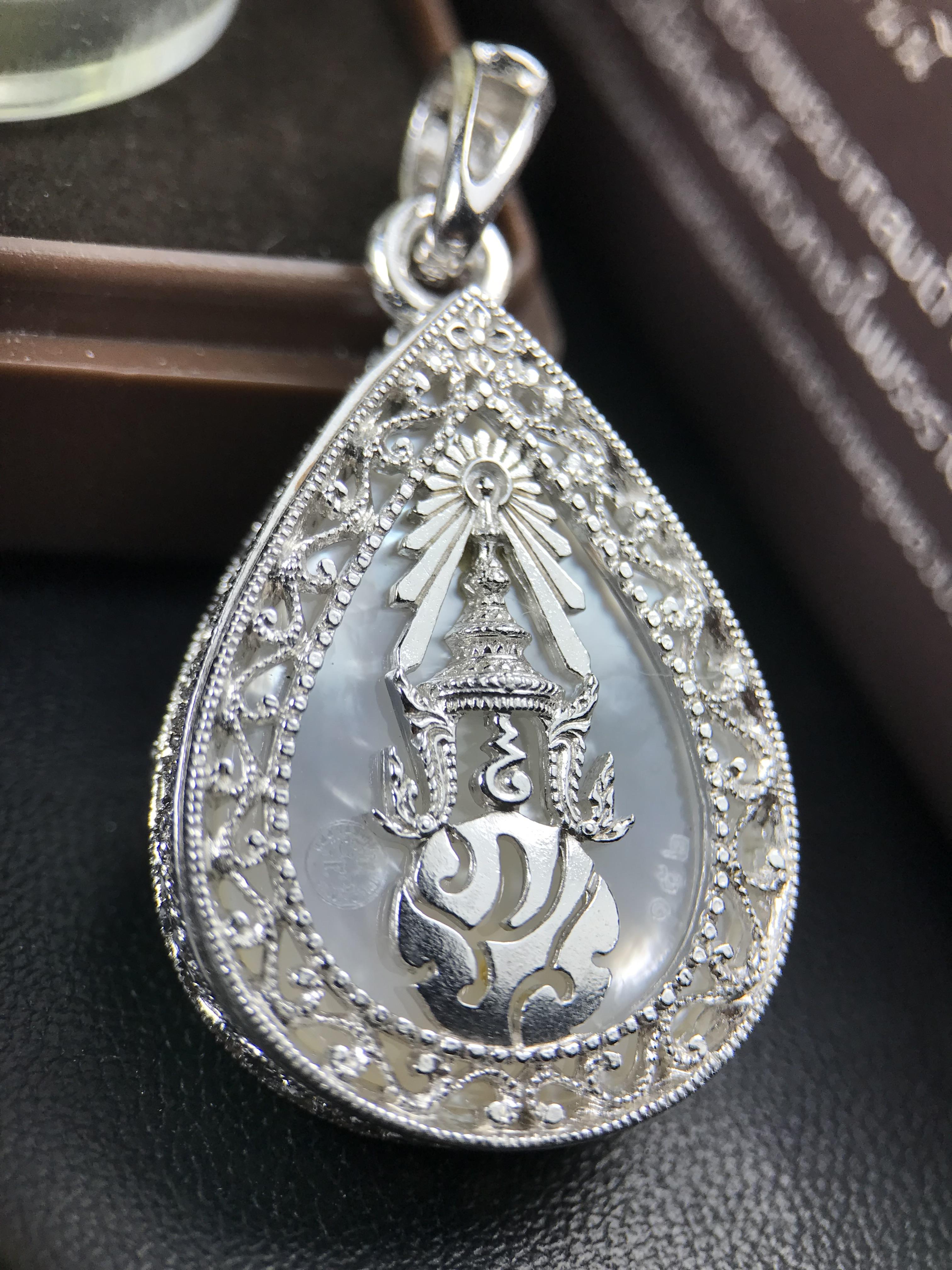 พระพุทธชินราช ภปร. โครงการ "เพราะแผ่นดินนี้ คือ แผ่นดินเกิด" ปี 2548(รุ่นแรก) เหรียญทรงหยดน้ำ ขนาด 21 x 31 มม. เนื้อเงินสามกษัตริย์ องค์พระชุบสามกษัตริย์ ล้อมด้วยกรอบเงินชุบทองคำขาวสลักเสลาเป็นลวดลายละเอียดอ่อน ส่วนพื้นองค์พระเป็นเปลือกหอยมุข