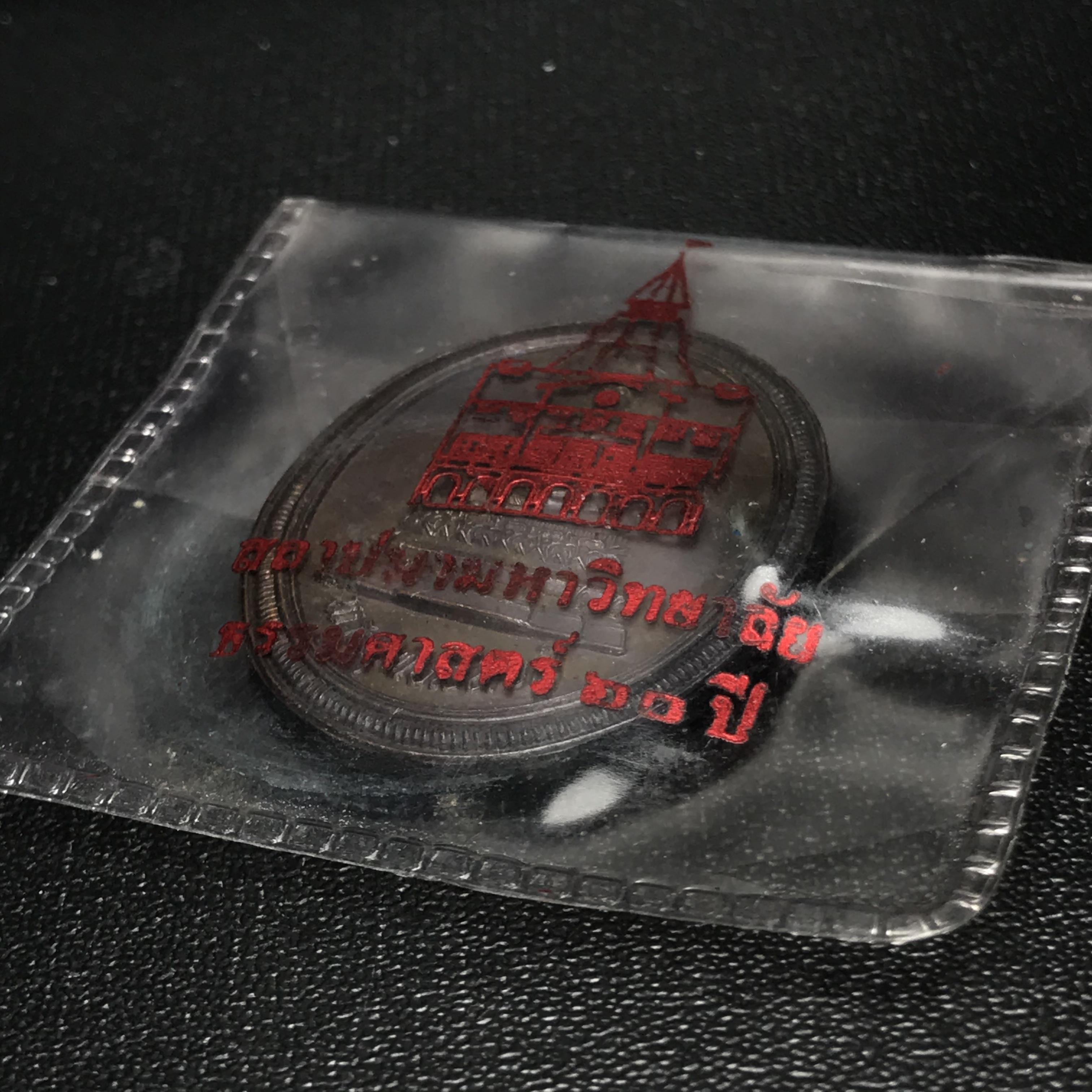 เหรียญพระพุทธสิหิงค์ ภปร. รุ่นมหาลัยธรรมศาสตร์ 60ปี พ.ศ.2537 พิมพ์ใหญ่กรรมการ(ไม่มีหูห่วง)เนื้อทองแดงซองบรรจุเดิม(ในหลวงรัชกาลที่9เสด็จในพิธี)(หลวงตามหาบัวร่วมปลุกเสก)