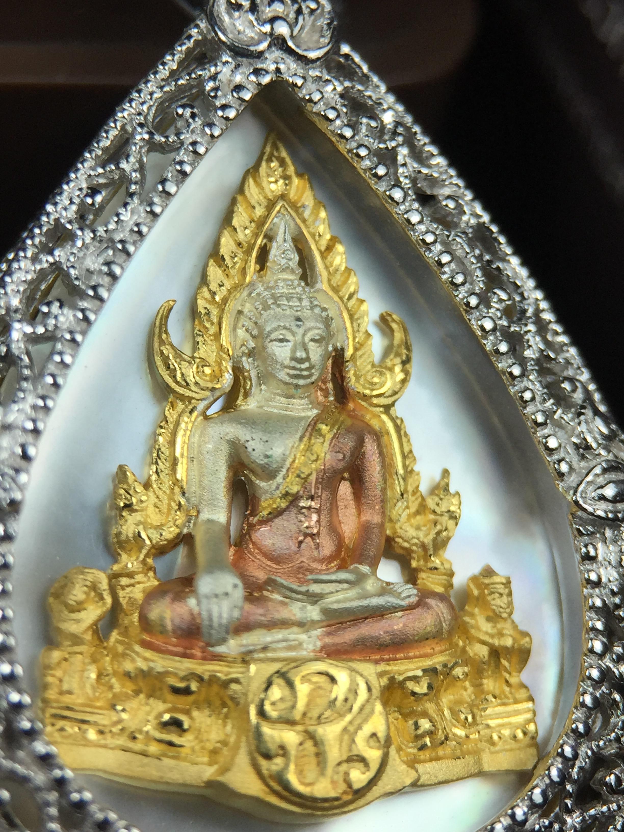 พระพุทธชินราช ภปร. โครงการ "เพราะแผ่นดินนี้ คือ แผ่นดินเกิด" ปี2548(รุ่นแรก) เหรียญทรงหยดน้ำ ขนาด 21 x 31 มม. เนื้อเงินสามกษัตริย์ องค์พระชุบสามกษัตริย์ ล้อมด้วยกรอบเงินชุบทองคำขาวสลักเสลาเป็นลวดลายละเอียดอ่อน ส่วนพื้นองค์พระเป็นเปลือกหอยมุข