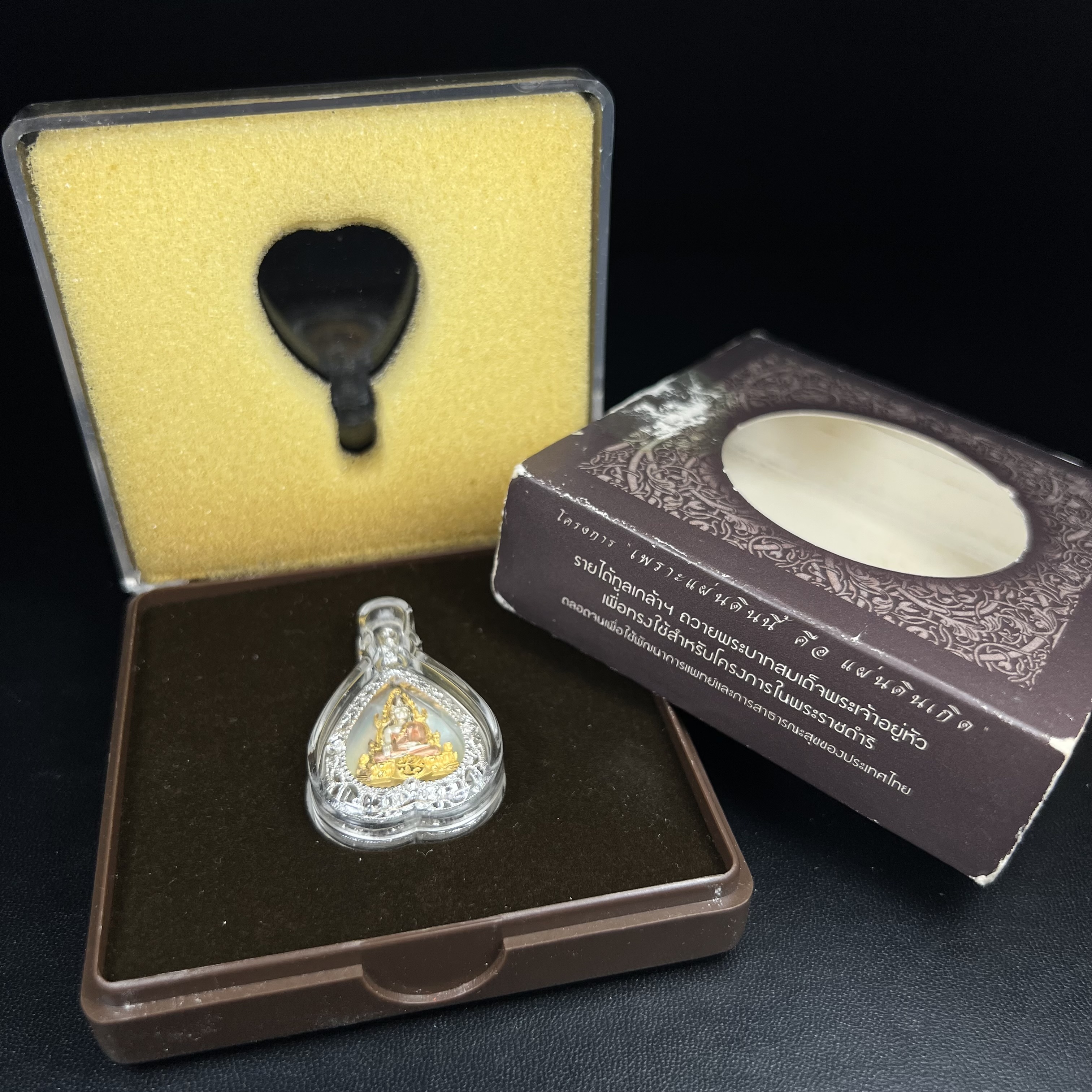 พระพุทธชินราช ภปร. โครงการ "เพราะแผ่นดินนี้ คือ แผ่นดินเกิด" ปี2548(รุ่นแรก) เหรียญทรงใบโพธิ์ ขนาด 21 x 29 มม. เนื้อเงินสามกษัตริย์ องค์พระชุบสามกษัตริย์ ล้อมด้วยกรอบเงินชุบทองคำขาวสลักเสลาเป็นลวดลายละเอียดอ่อน ส่วนพื้นองค์พระเป็นเปลือกหอยมุข