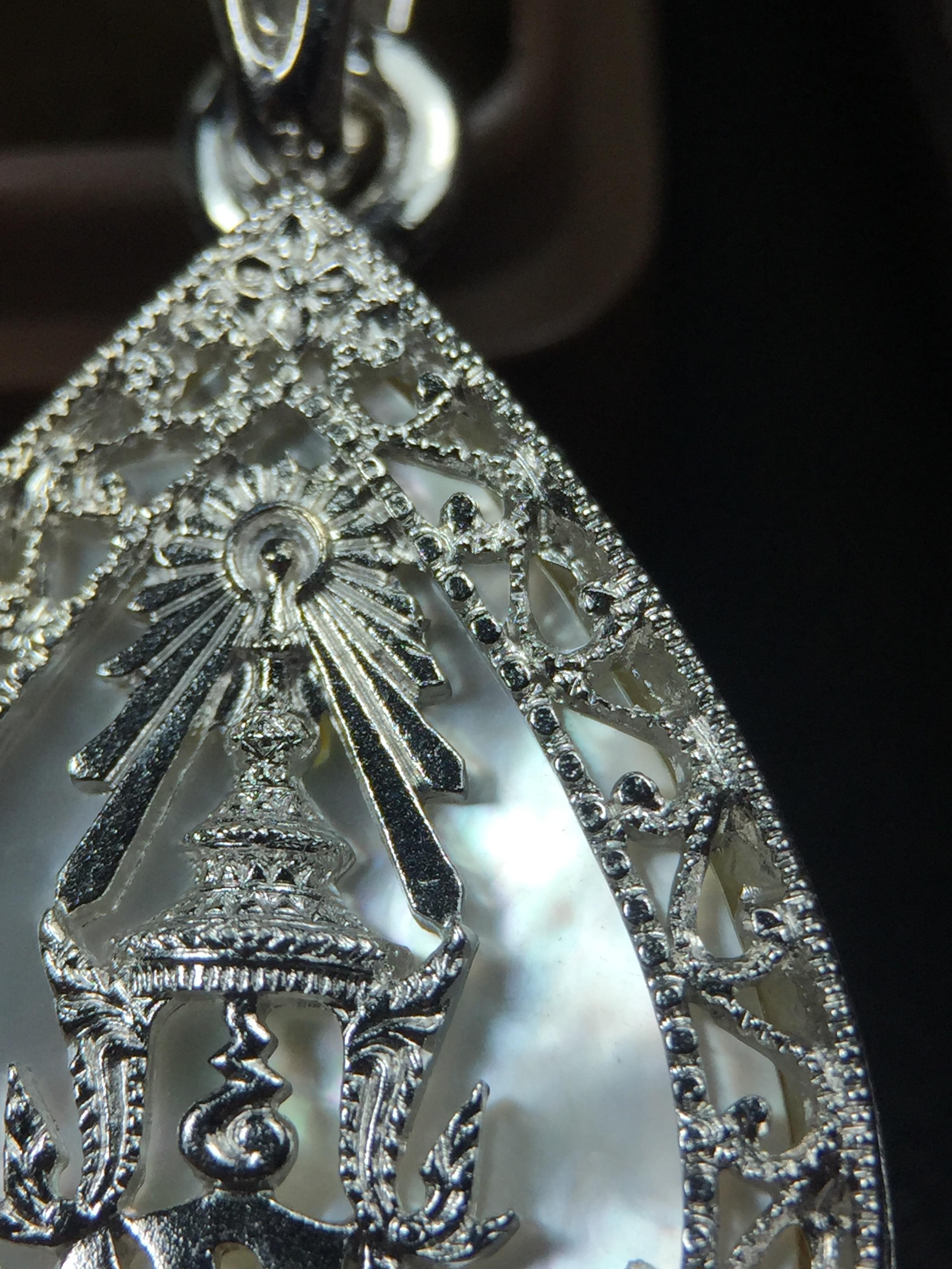 พระพุทธชินราช ภปร. โครงการ "เพราะแผ่นดินนี้ คือ แผ่นดินเกิด" ปี2548(รุ่นแรก) เหรียญทรงหยดน้ำ ขนาด 21 x 31 มม. เนื้อเงินสามกษัตริย์ องค์พระชุบสามกษัตริย์ ล้อมด้วยกรอบเงินชุบทองคำขาวสลักเสลาเป็นลวดลายละเอียดอ่อน ส่วนพื้นองค์พระเป็นเปลือกหอยมุข