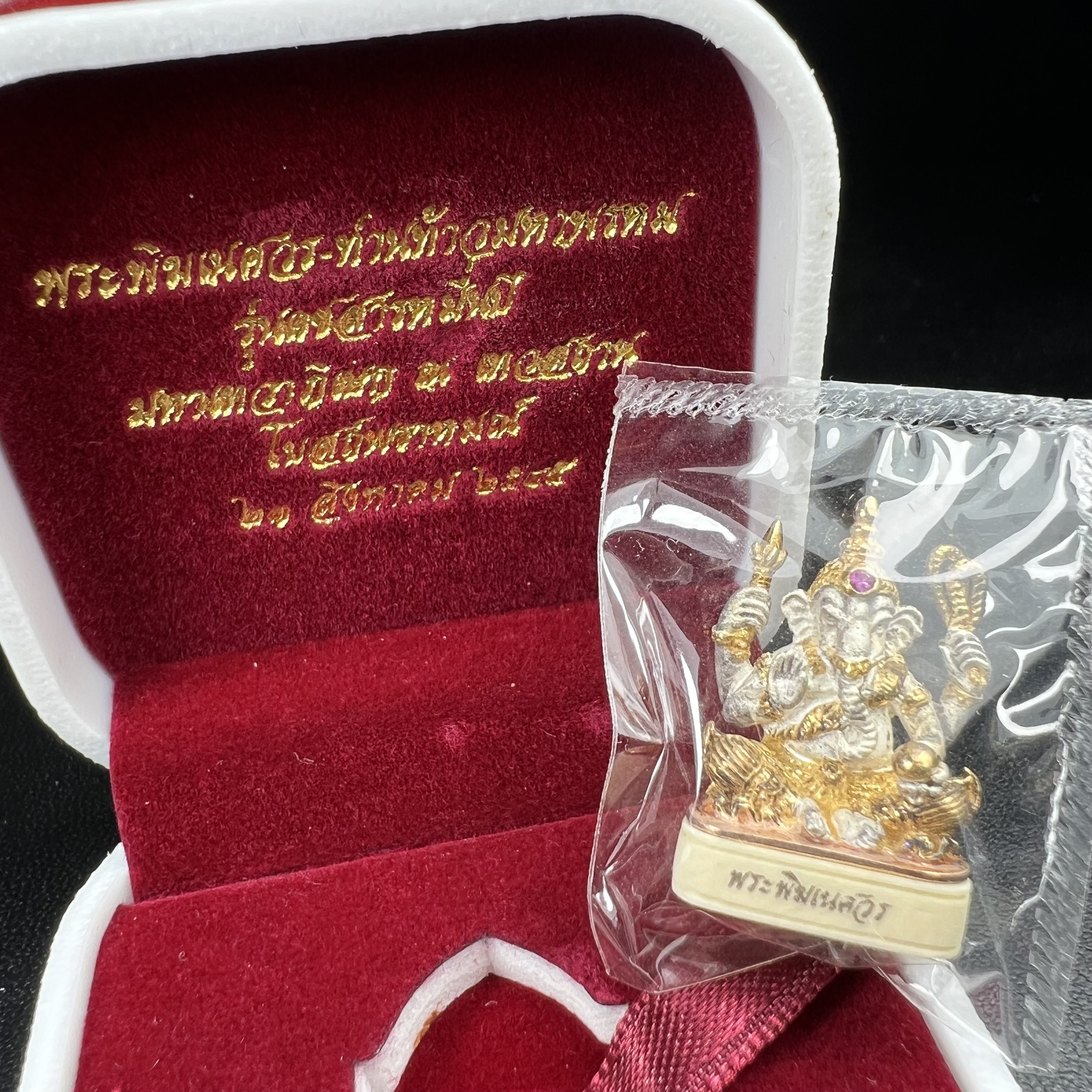 พระพิฆเนศวร รุ่น คชสารหมื่นปี รูปเหมือนพระพิฆเนศวรนั่งประทานพรฐานงาช้างแมมมอสขนาดห้อยคอ เนื้อเงินชุบสามกษัตริย์ขัดเงา พิมพ์เล็ก สูง 2.2 ซม. ฝังพลอยทับทิมแท้ พิธีมหาเทวาภิเษก ณ. เทวสถานโบสถ์พราหมณ์ (เสาชิงช้า) โดยเกจิคณาจารย์ทั่วประทศ ปี 2545(หมายเลข ๓๐)