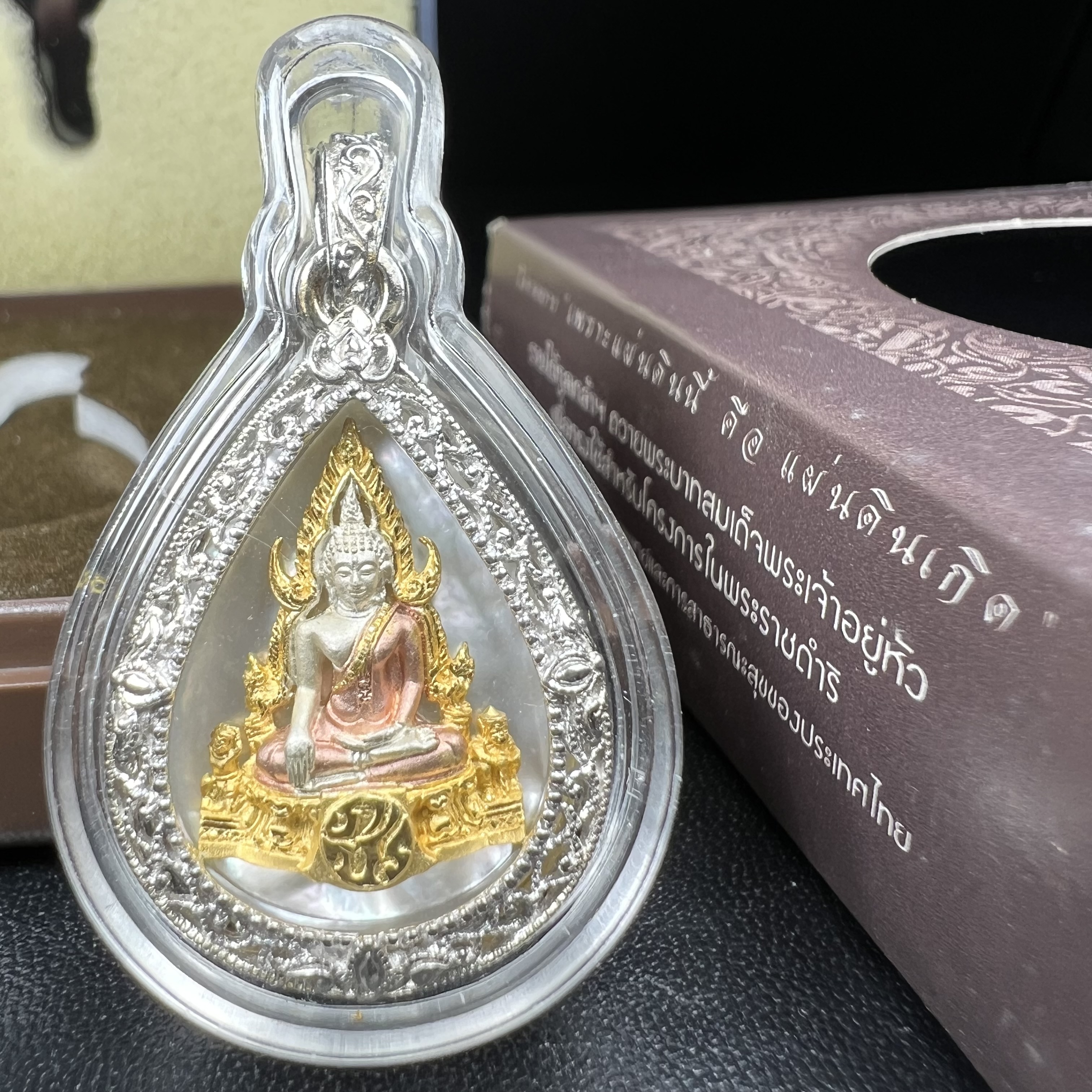 พระพุทธชินราช ภปร. โครงการ "เพราะแผ่นดินนี้ คือ แผ่นดินเกิด" ปี2548(รุ่นแรก) เหรียญทรงหยดน้ำ ขนาด 21 x 31 มม. เนื้อเงินสามกษัตริย์ องค์พระชุบสามกษัตริย์ ล้อมด้วยกรอบเงินชุบทองคำขาวสลักเสลาเป็นลวดลายละเอียดอ่อน ส่วนพื้นองค์พระเป็นเปลือกหอยมุข