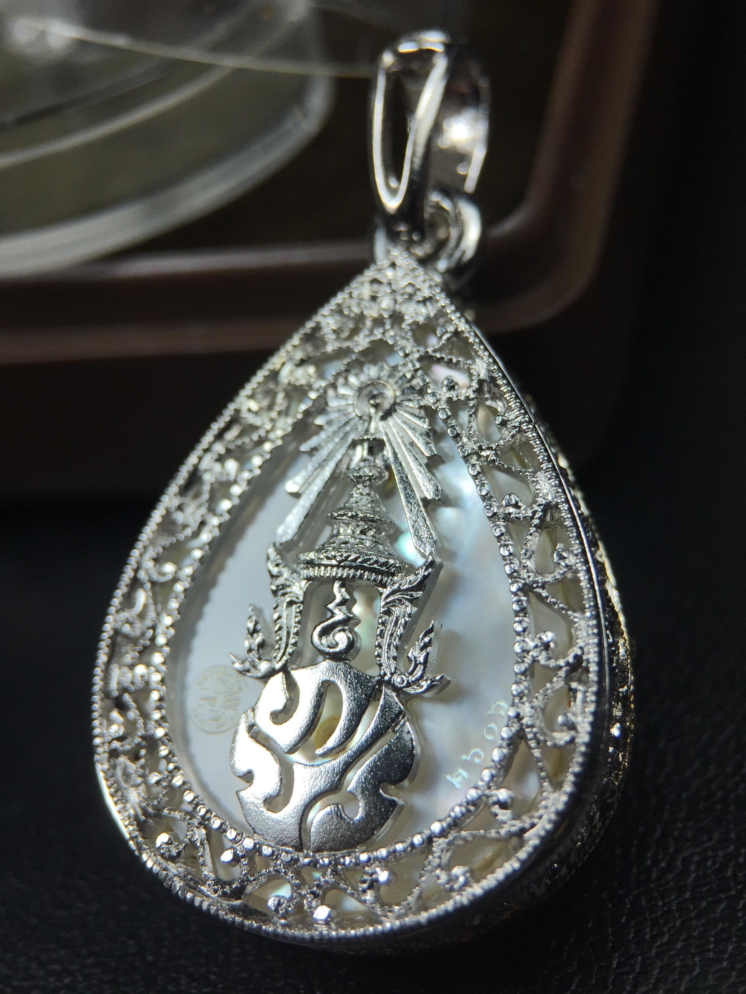 พระพุทธชินราช ภปร. โครงการ "เพราะแผ่นดินนี้ คือ แผ่นดินเกิด" ปี2548(รุ่นแรก) เหรียญทรงหยดน้ำ ขนาด 21 x 31 มม. เนื้อเงินสามกษัตริย์ องค์พระชุบสามกษัตริย์ ล้อมด้วยกรอบเงินชุบทองคำขาวสลักเสลาเป็นลวดลายละเอียดอ่อน ส่วนพื้นองค์พระเป็นเปลือกหอยมุข