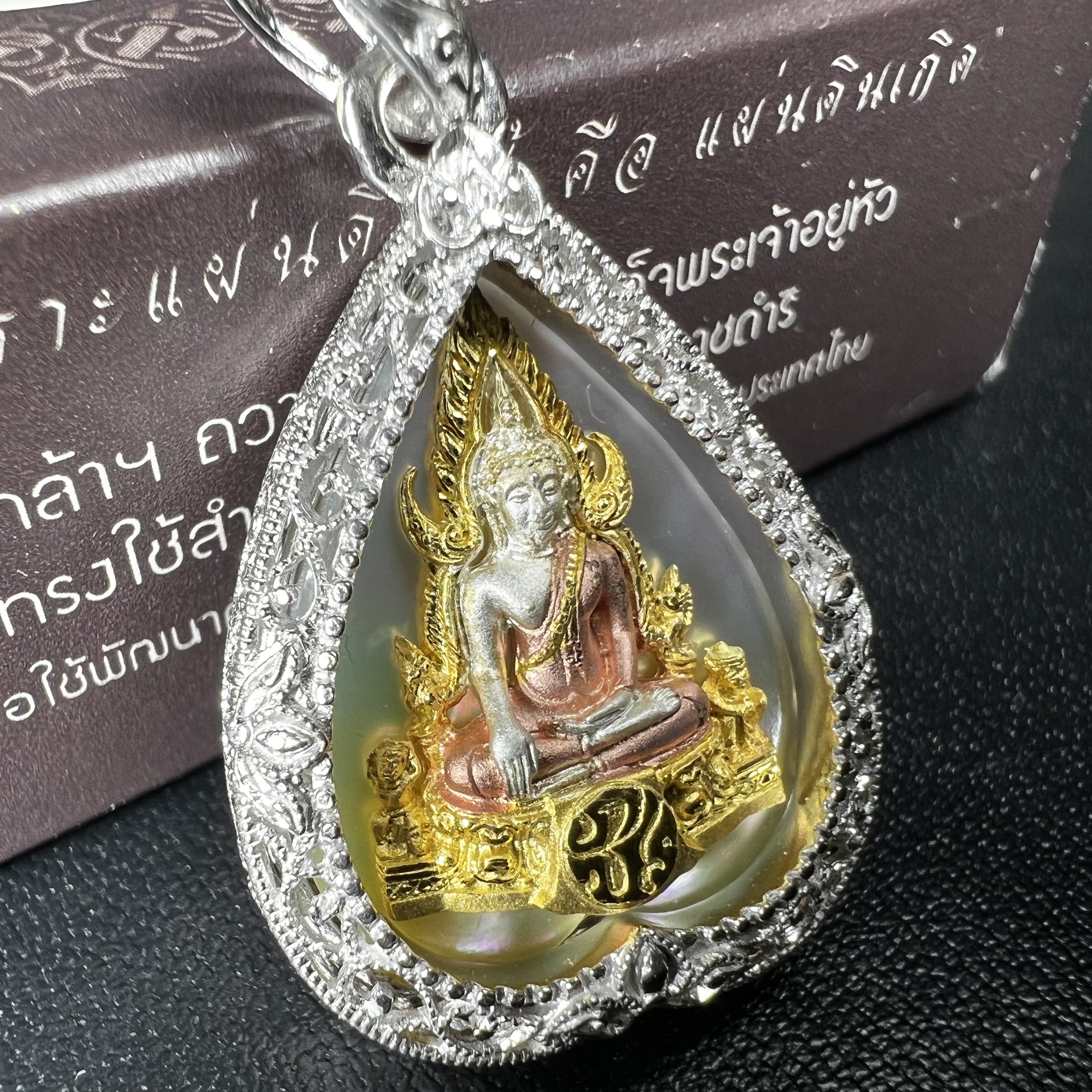 พระพุทธชินราช ภปร. โครงการ "เพราะแผ่นดินนี้ คือ แผ่นดินเกิด" ปี2548(รุ่นแรก) เหรียญทรงใบโพธิ์ ขนาด 21 x 29 มม. เนื้อเงินสามกษัตริย์ องค์พระชุบสามกษัตริย์ ล้อมด้วยกรอบเงินชุบทองคำขาวสลักเสลาเป็นลวดลายละเอียดอ่อน ส่วนพื้นองค์พระเป็นเปลือกหอยมุข