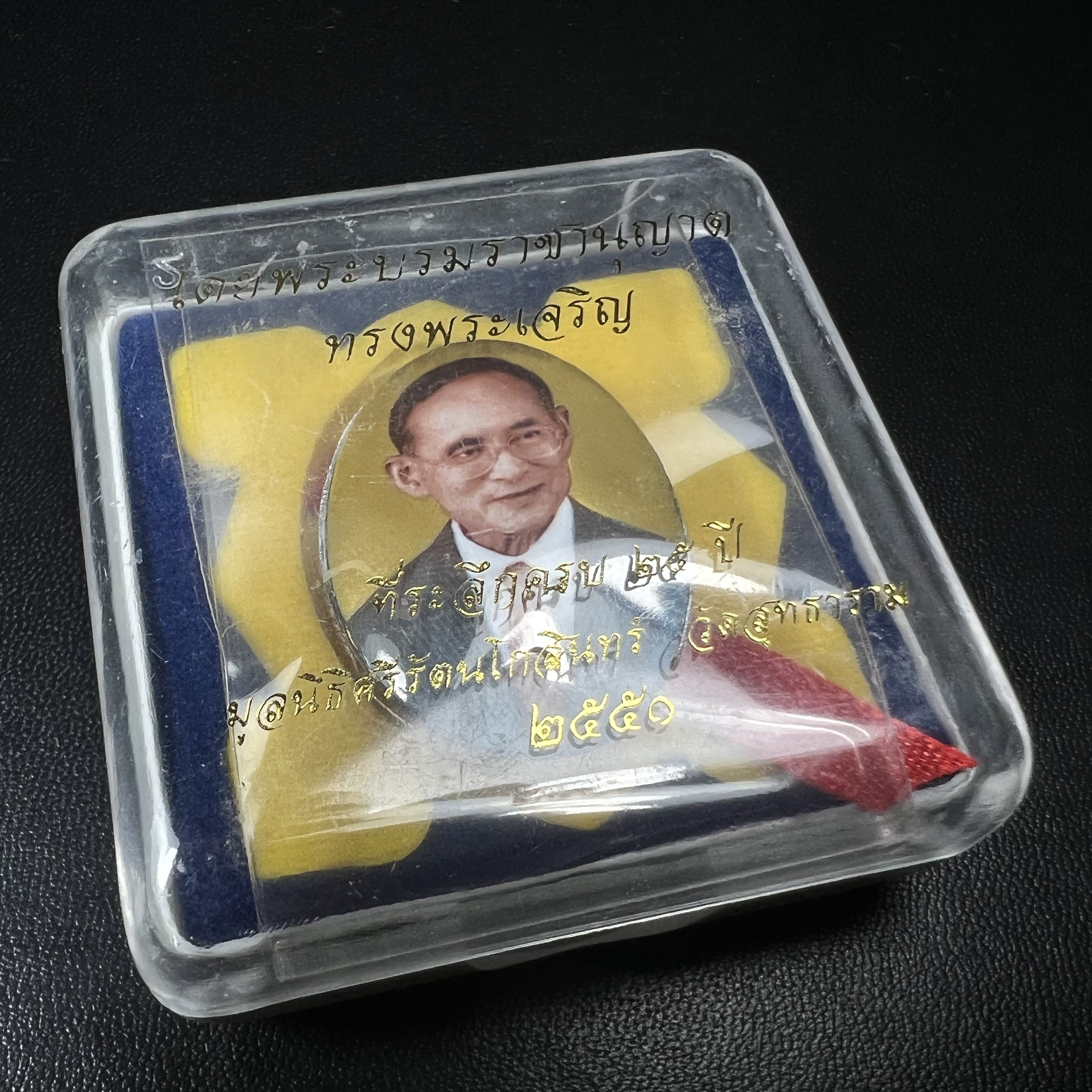 ล็อกเกตในหลวงรัชกาลที่9 ที่ระลึกครบ 25 ปี มูลนิธิศรีรัตนโกสินทร์ วัดสุทธาราม พ.ศ. 2550 พิมพ์ทรงวงรีรูปไข่เล็กฉากสีทอง หลังปิดแผ่นโลหะสีขาว(สแตนเลส)ฝังพระยอดธง(นิยม)