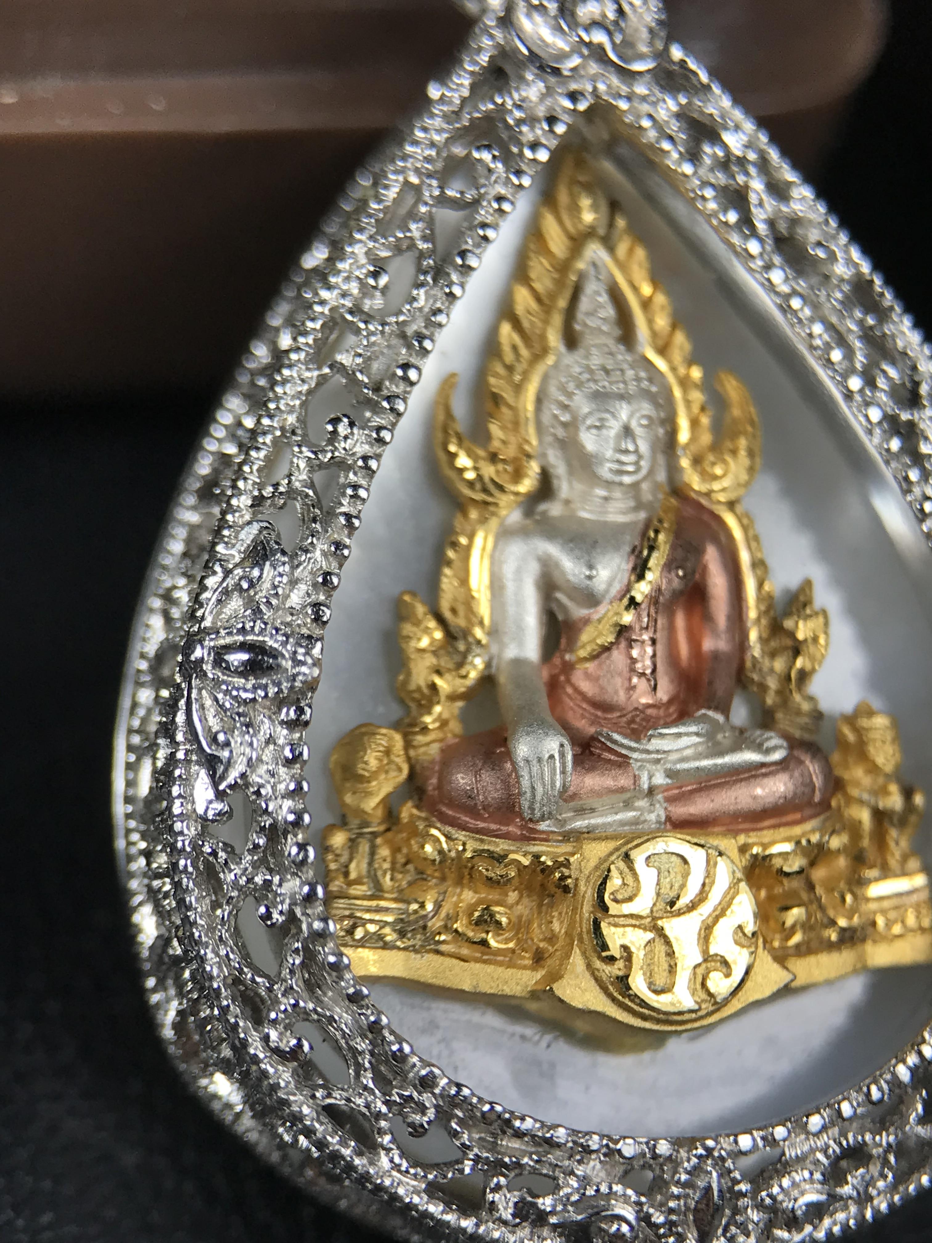 พระพุทธชินราช ภปร. โครงการ "เพราะแผ่นดินนี้ คือ แผ่นดินเกิด" ปี 2548(รุ่นแรก) เหรียญทรงหยดน้ำ ขนาด 21 x 31 มม. เนื้อเงินสามกษัตริย์ องค์พระชุบสามกษัตริย์ ล้อมด้วยกรอบเงินชุบทองคำขาวสลักเสลาเป็นลวดลายละเอียดอ่อน ส่วนพื้นองค์พระเป็นเปลือกหอยมุข