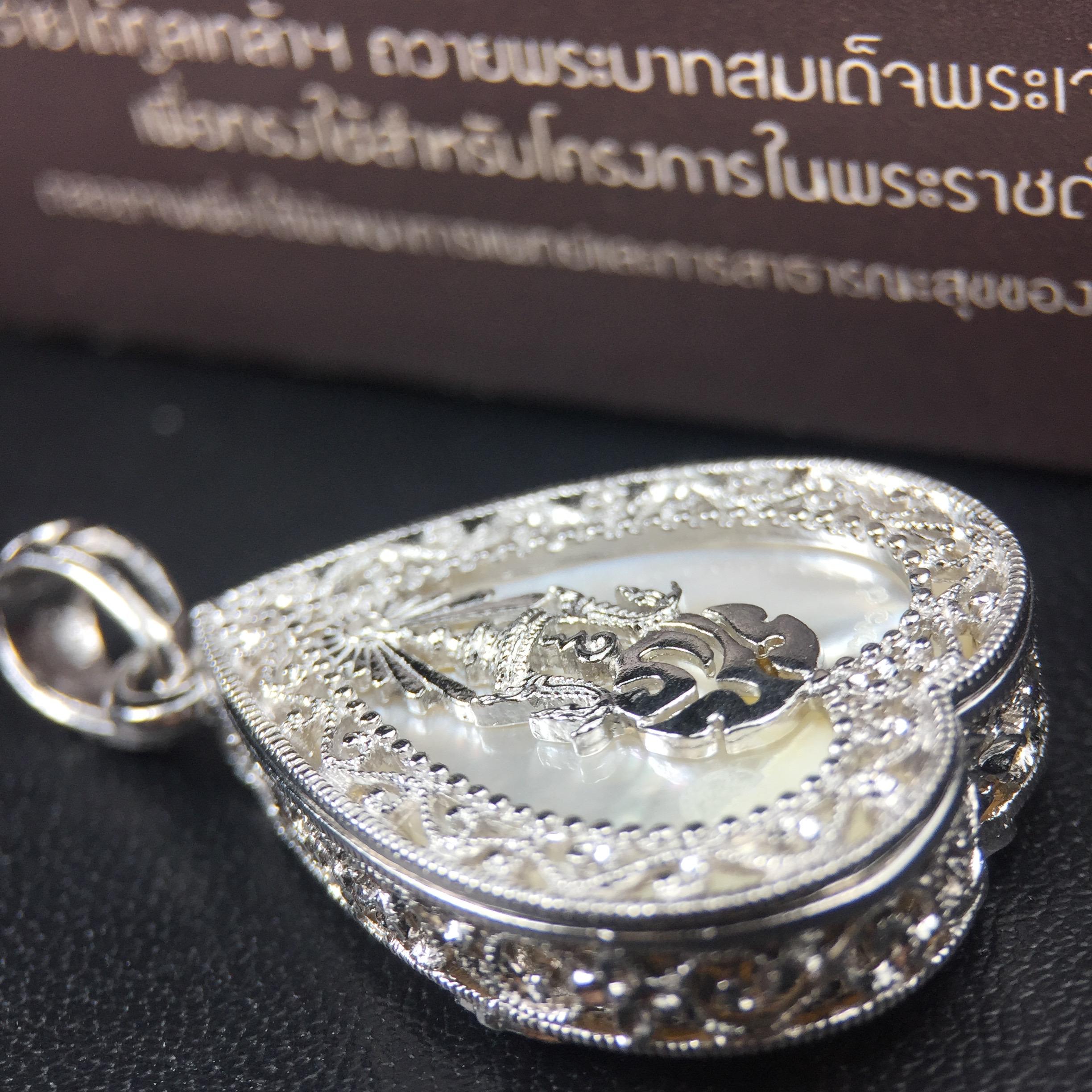 พระพุทธชินราช ภปร. โครงการ "เพราะแผ่นดินนี้ คือ แผ่นดินเกิด" ปี2548(รุ่นแรก) เหรียญทรงใบโพธิ์ ขนาด 21 x 29 มม. เนื้อเงินสามกษัตริย์ องค์พระชุบสามกษัตริย์ ล้อมด้วยกรอบเงินชุบทองคำขาวสลักเสลาเป็นลวดลายละเอียดอ่อน ส่วนพื้นองค์พระเป็นเปลือกหอยมุข