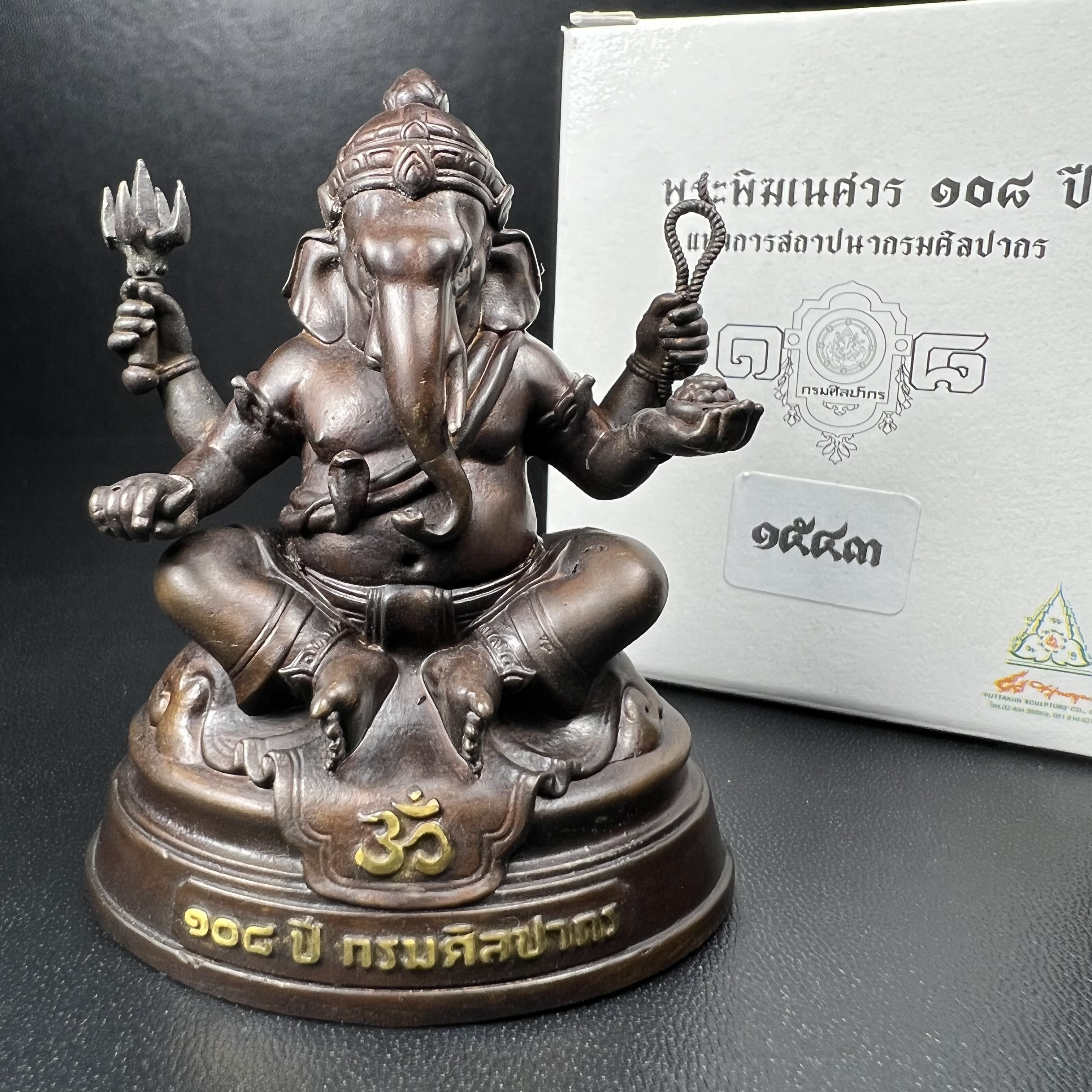 พระพิฆเนศวร รุ่น 108 ปี แห่งการสถาปนากรมศิลปากร ปี 2562 ขนาดบูชาหน้าตัก 1.5 นิ้ว เนื้อทองเหลืองรมดำ (พิธีใหญ่ มวลสารดี)(เลขนัมเบอร์ 1543)1 ใน 1999 องค์