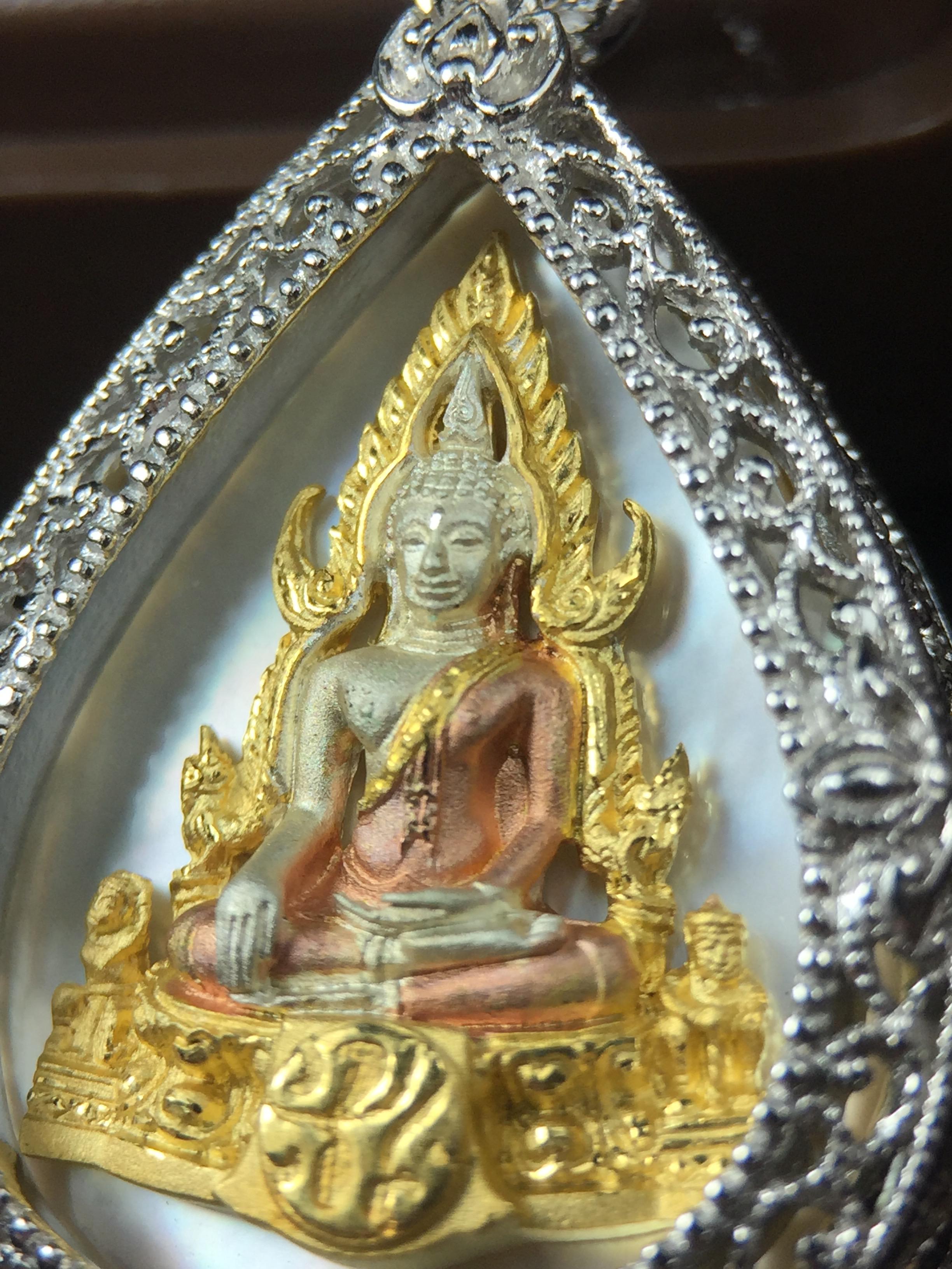 พระพุทธชินราช ภปร. โครงการ "เพราะแผ่นดินนี้ คือ แผ่นดินเกิด" ปี2548(รุ่นแรก) เหรียญทรงหยดน้ำ ขนาด 21 x 31 มม. เนื้อเงินสามกษัตริย์ องค์พระชุบสามกษัตริย์ ล้อมด้วยกรอบเงินชุบทองคำขาวสลักเสลาเป็นลวดลายละเอียดอ่อน ส่วนพื้นองค์พระเป็นเปลือกหอยมุข