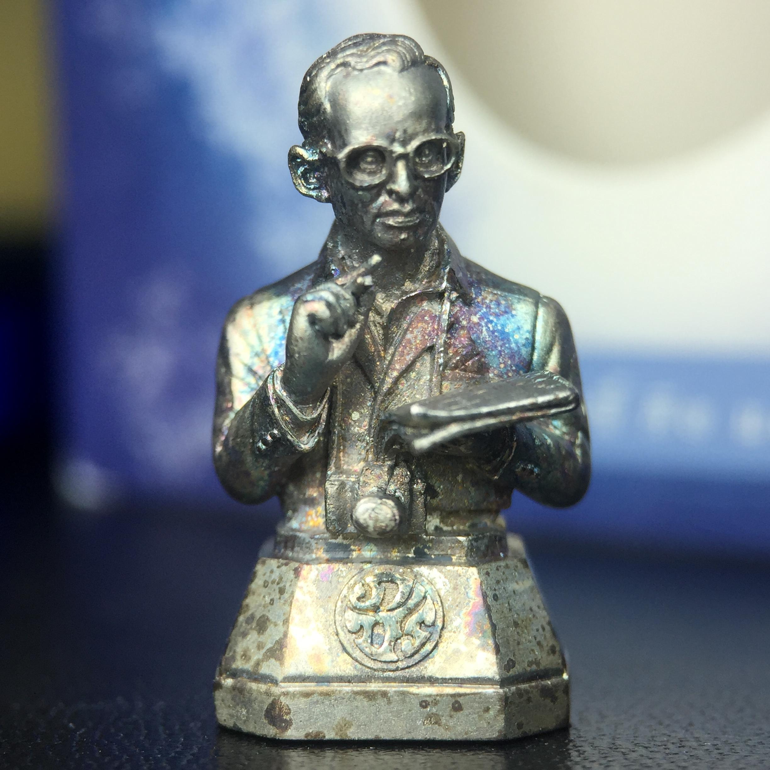 พระบรมรูปพระบาทสมเด็จพระเจ้าอยู่หัวรัชกาลที่ 9(ทรงงาน) ภปร. รุ่นเพราะแผ่นดินนี้คือแผ่นดินเกิด ปี 2551 ขนาดสูง 1 นิ้ว เนื้อเงิน(ผิวเดิมขึ้นสีรุ้งธรรมชาติสวยมาก)(ด้านหน้า ฐานพระบรมรูปฯ ประดิษฐานอักษรพระปรมาภิไธย ภ.ป.ร.)นิยมหายาก(1 ใน 5000 องค์)