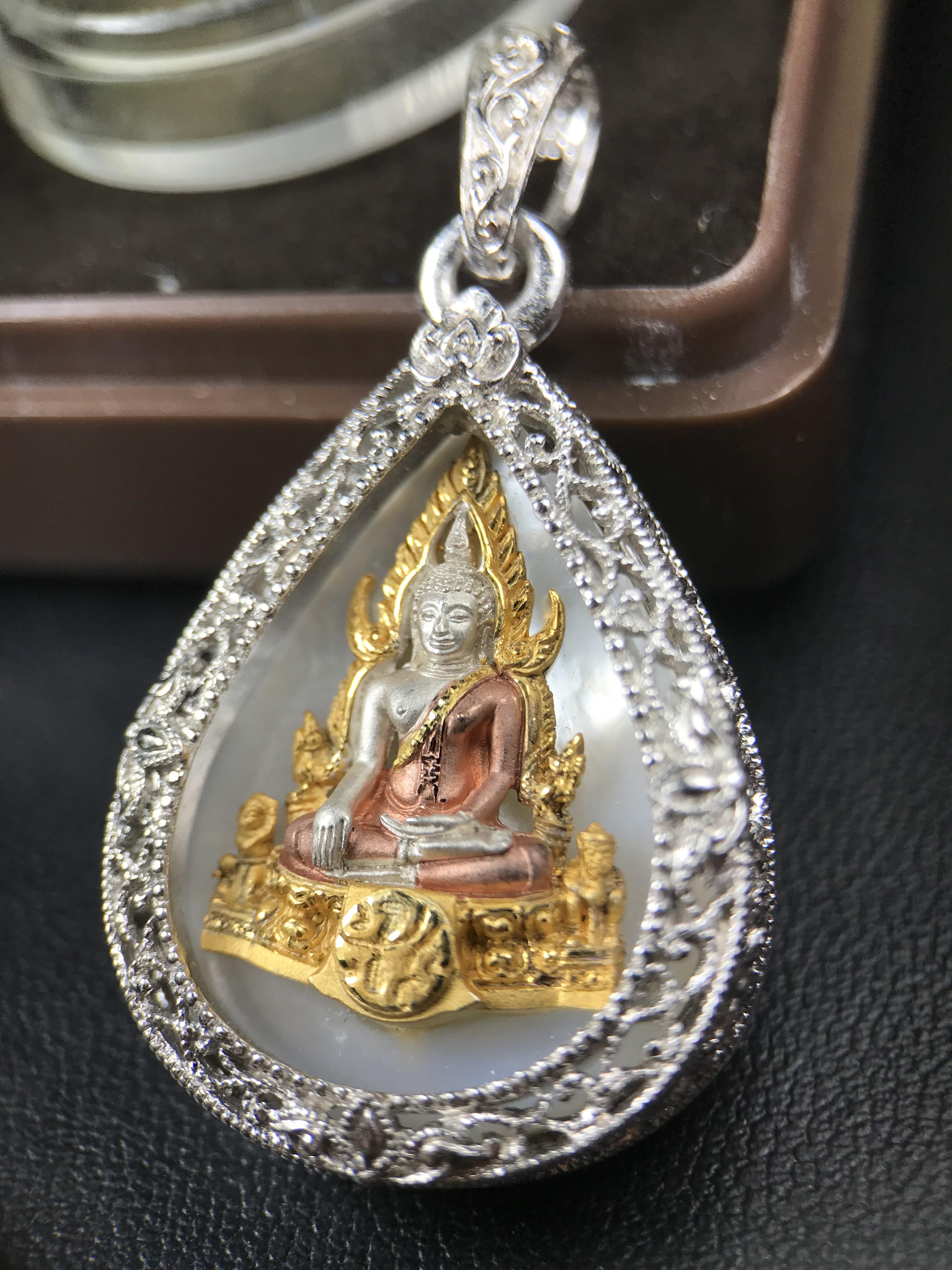 พระพุทธชินราช ภปร. โครงการ "เพราะแผ่นดินนี้ คือ แผ่นดินเกิด" ปี 2548(รุ่นแรก) เหรียญทรงหยดน้ำ ขนาด 21 x 31 มม. เนื้อเงินสามกษัตริย์ องค์พระชุบสามกษัตริย์ ล้อมด้วยกรอบเงินชุบทองคำขาวสลักเสลาเป็นลวดลายละเอียดอ่อน ส่วนพื้นองค์พระเป็นเปลือกหอยมุข