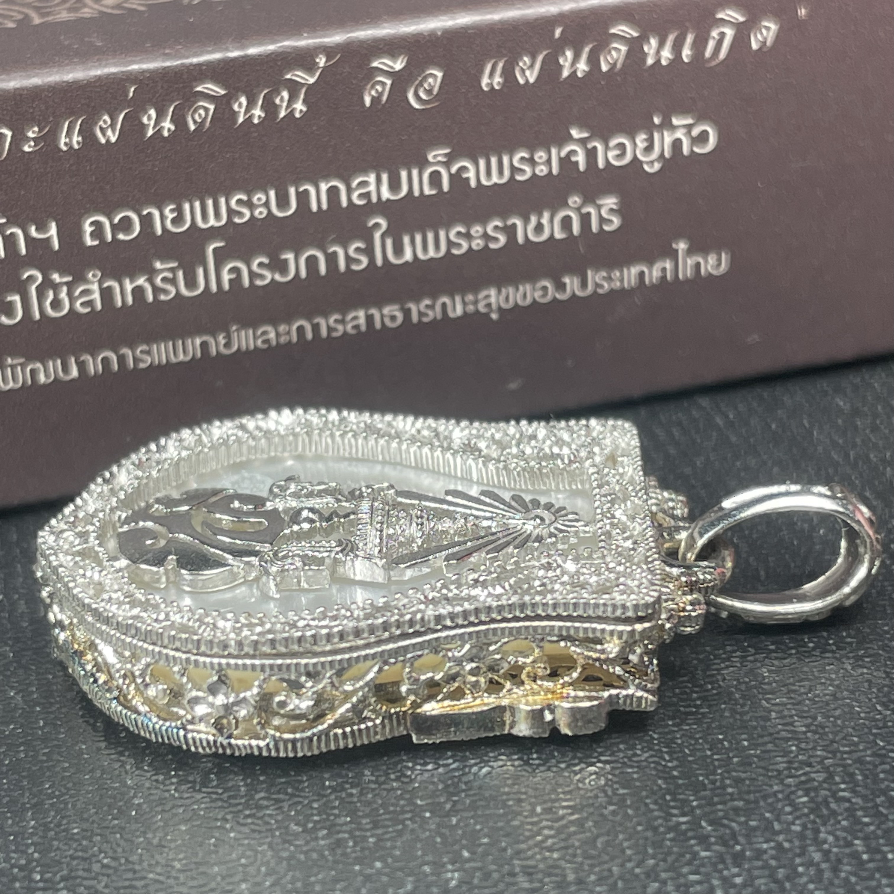 พระพุทธชินราช ภปร. โครงการ "เพราะแผ่นดินนี้ คือ แผ่นดินเกิด" ปี2548(รุ่นแรก) เหรียญทรงเสมา ขนาด 21 x 29 มม.เนื้อเงินสามกษัตริย์ องค์พระชุบสามกษัตริย์ ล้อมด้วยกรอบเงินชุบทองคำขาวสลักเสลาเป็นลวดลายละเอียดอ่อน ส่วนพื้นองค์พระเป็นเปลือกหอยมุขงดงาม