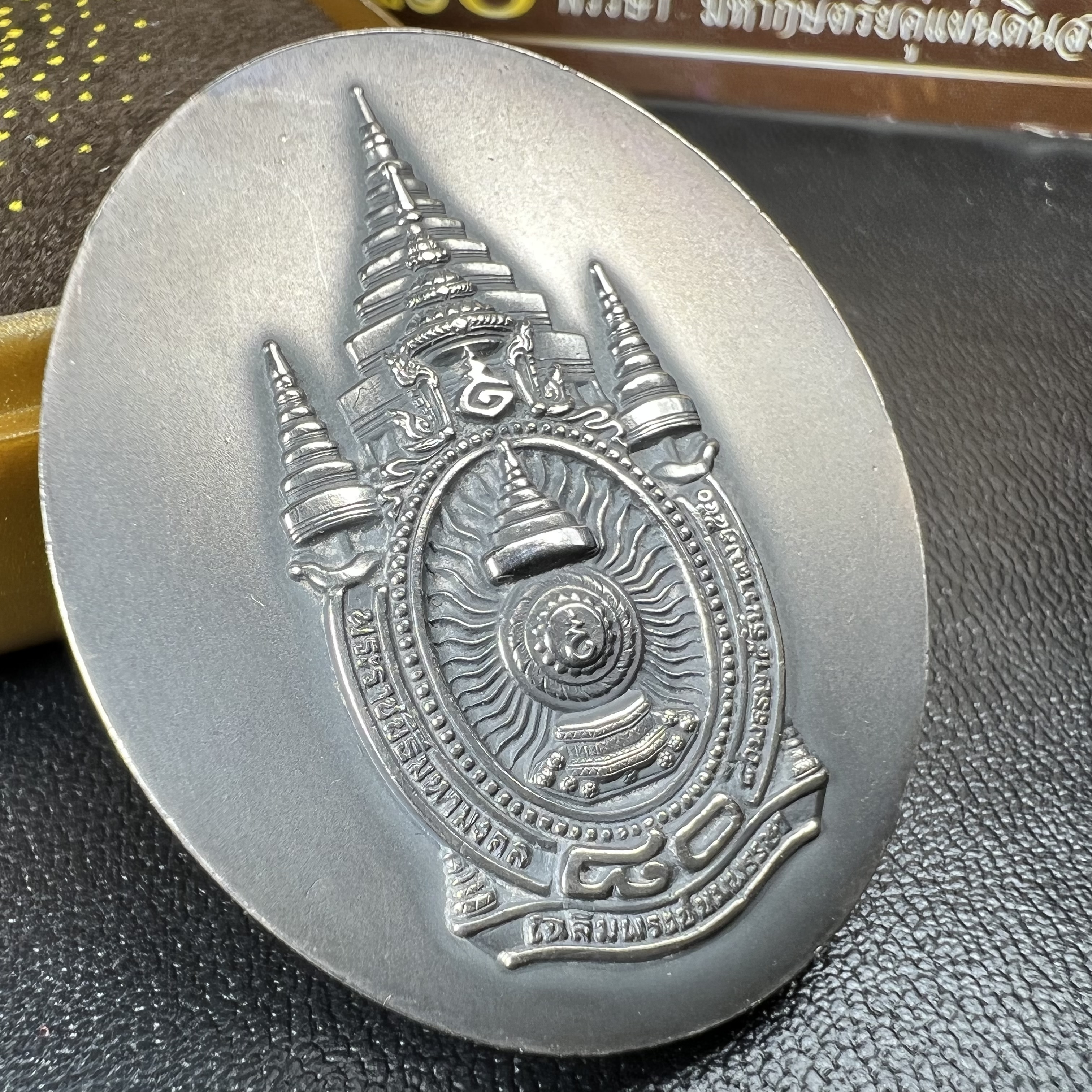 เหรียญรูปหล่อพระบาทสมเด็จพระเจ้าอยู่หัว ในหลวงทรงงาน “รุ่นเย็นศิระเพราะพระบริบาล 80พรรษา มหากษัตริย์คู่แผ่นดินสยาม” พ.ศ.2550 เนื้อเงินรมดำ(ขนาด 27*35 มม.) พร้อมกล่องบรรจุเดิมครบ