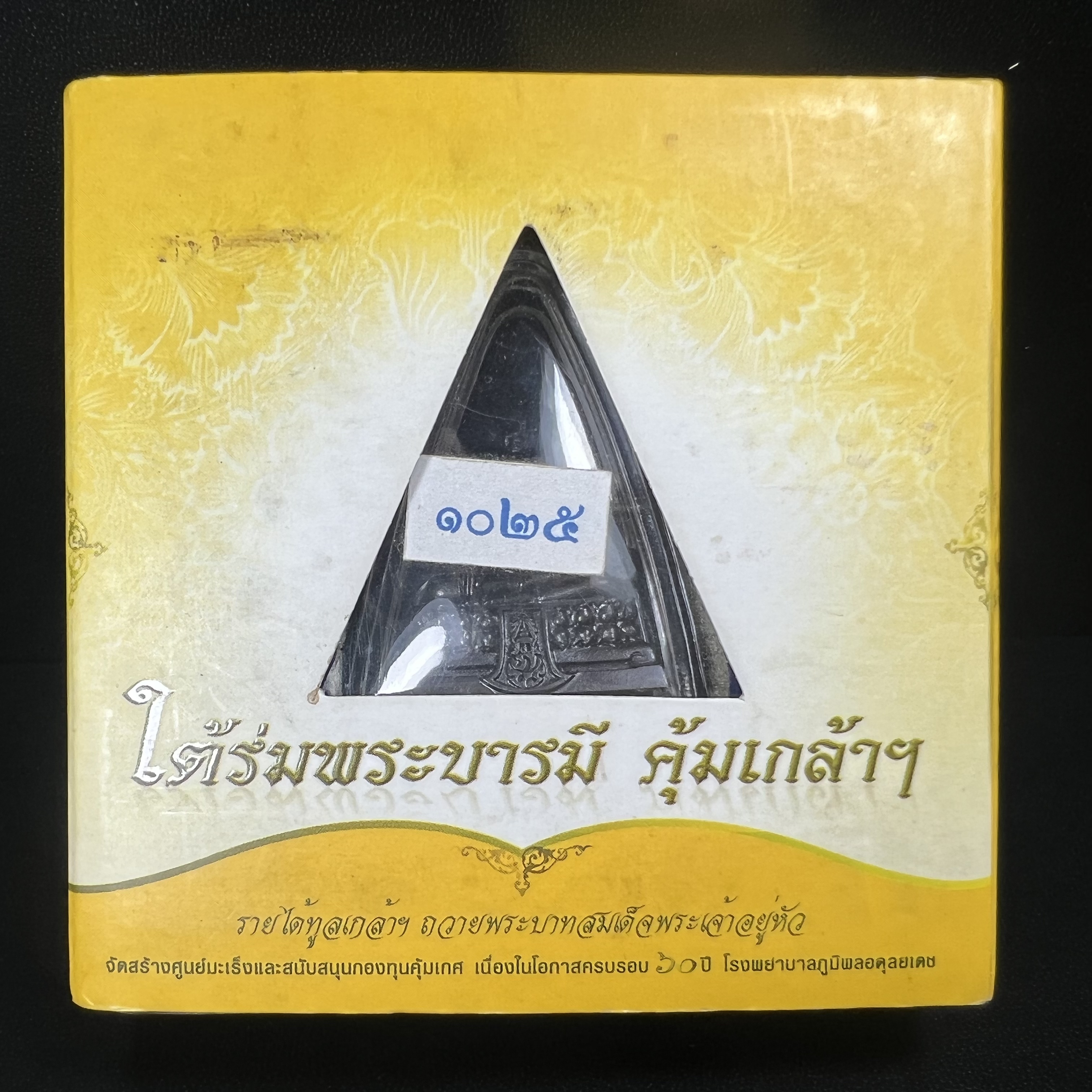 พระพุทธรูปคุ้มเกล้าฯ ภปร.(ใต้ร่มพระบารมี คุ้มเกล้า) 60ปี รพ.ภูมิพลฯ พ.ศ.2552 เนื้อนวโลหะ รมดำ(พิมพ์ใหญ่ขนาด 35.5*24 มม.)