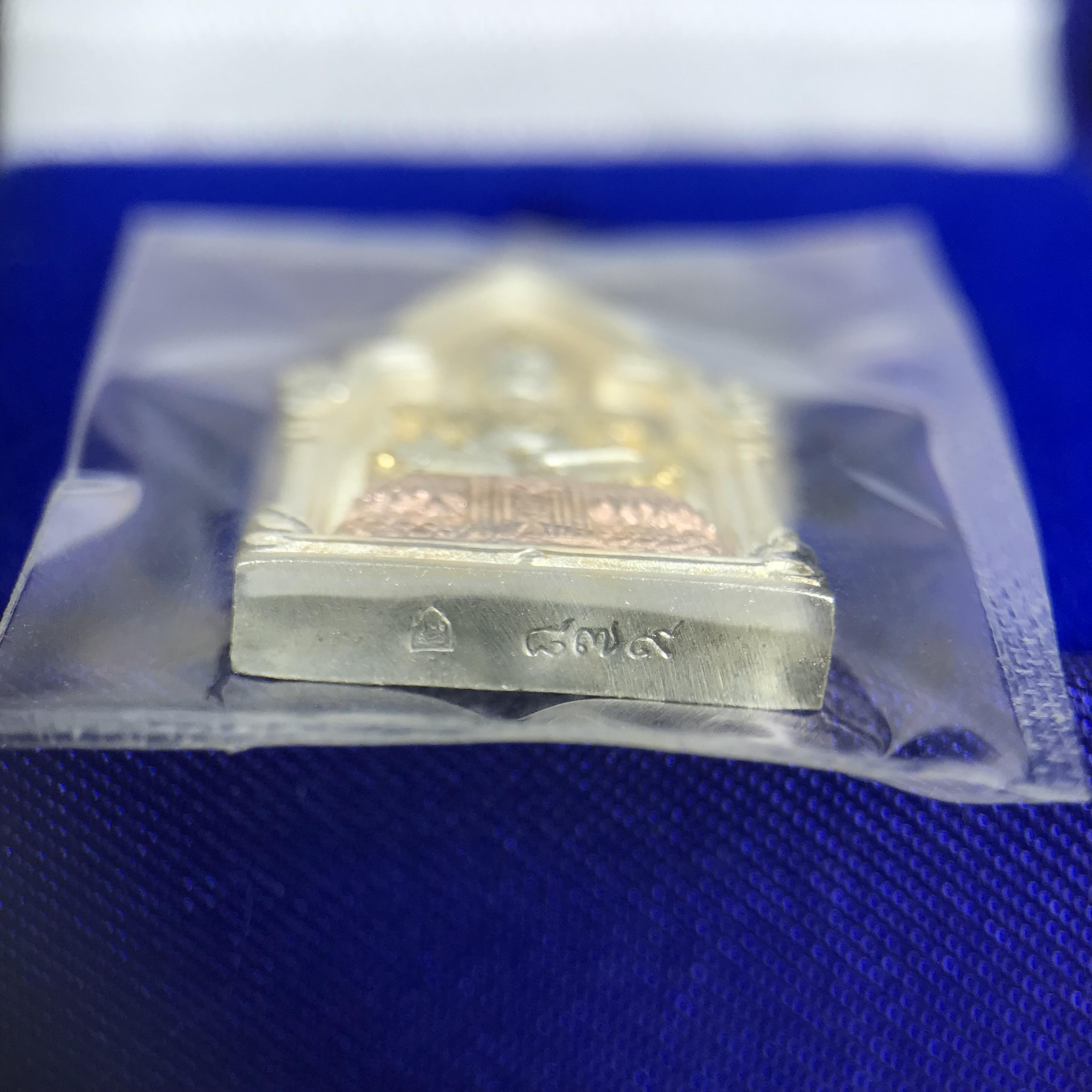 พระพุทธมหามณีรัตนปฎิมากร(พระแก้วมรกต)รุ่น เฉลิมพระเกียรติ วัดพระศรีรัตนศาสดารามราม(วัดพระแก้ว) ปี2543 เนื้อเงินสามกษัตริย์พิมพ์ซุ้มกนกเล็ก ขนาด สูง 2.5 ซ.ม. สภาพสวยซีนเดิมกล่องครบ(องค์หมายเลข ๘๗๙)