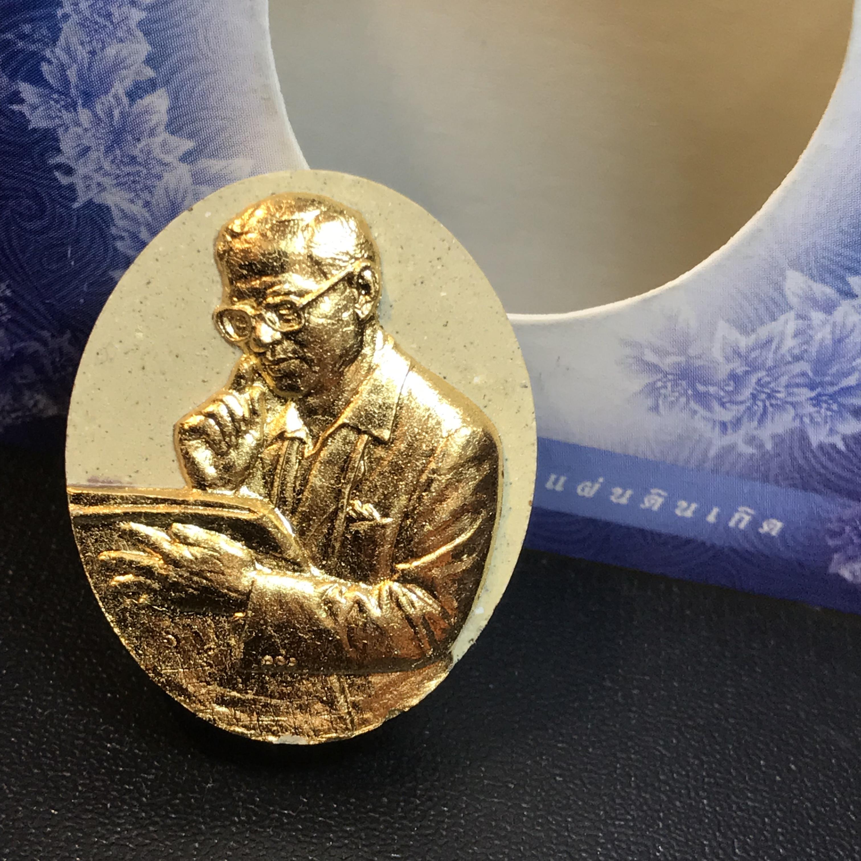 รูปหล่อพระบาทสมเด็จพระเจ้าอยู่หัว(ทรงงาน) ภปร. โครงการ เพราะแผ่นดินนี้คือแผ่นดินเกิด ปี2551 เนื้อผง ด้านหน้าปิดทอง หลัง ภ.ป.ร. ปิดทอง (มวลสารพระราชทานเส้นพระเจ้า (เส้นผม) ของพระบาทสมเด็จพระเจ้าอยู่หัวรัชกาลที่9