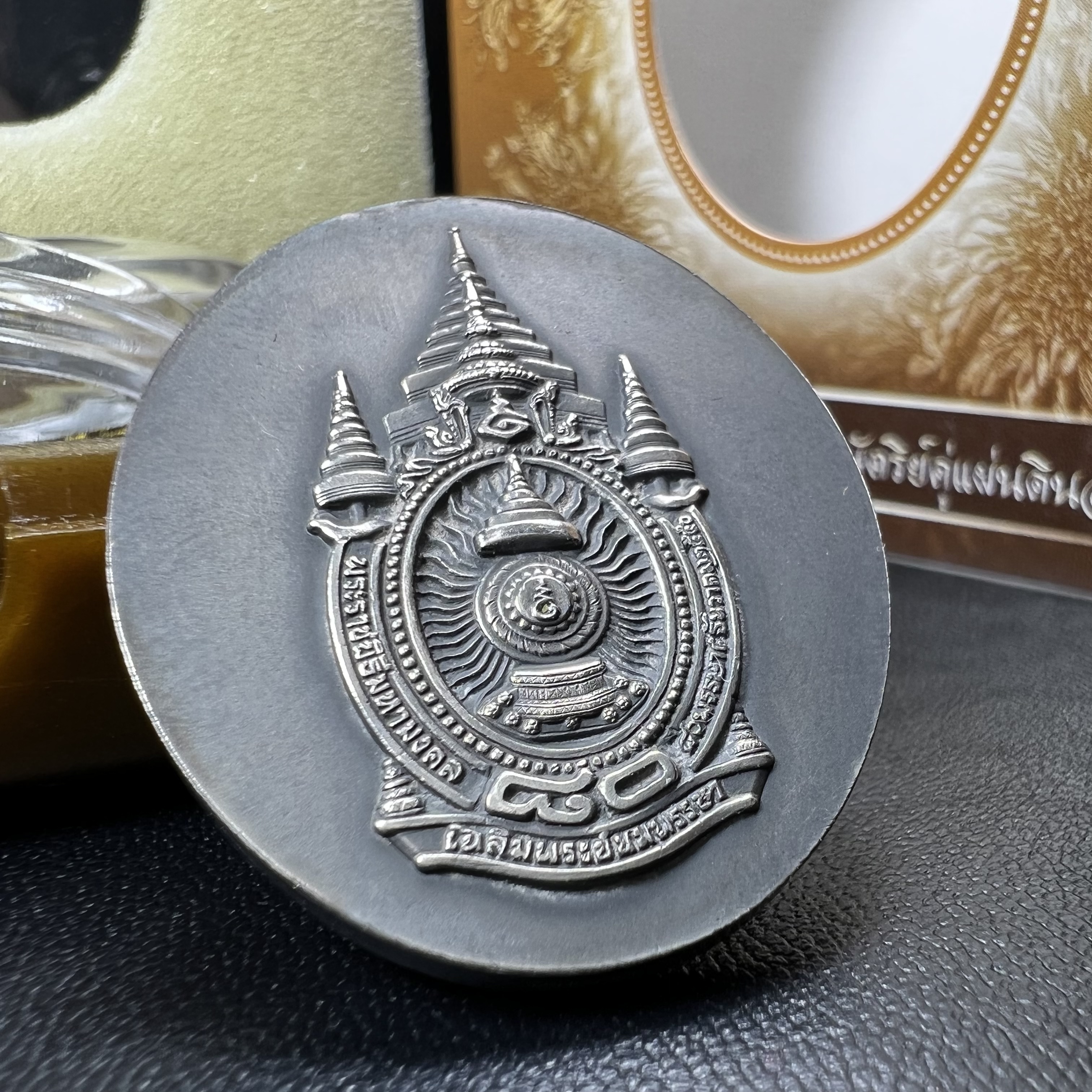 เหรียญรูปหล่อพระบาทสมเด็จพระเจ้าอยู่หัว ในหลวงทรงงาน “รุ่นเย็นศิระเพราะพระบริบาล 80พรรษา มหากษัตริย์คู่แผ่นดินสยาม” พ.ศ.2550 เนื้อเงินรมดำ(ขนาด 27*35 มม.) พร้อมกล่องบรรจุเดิมครบ