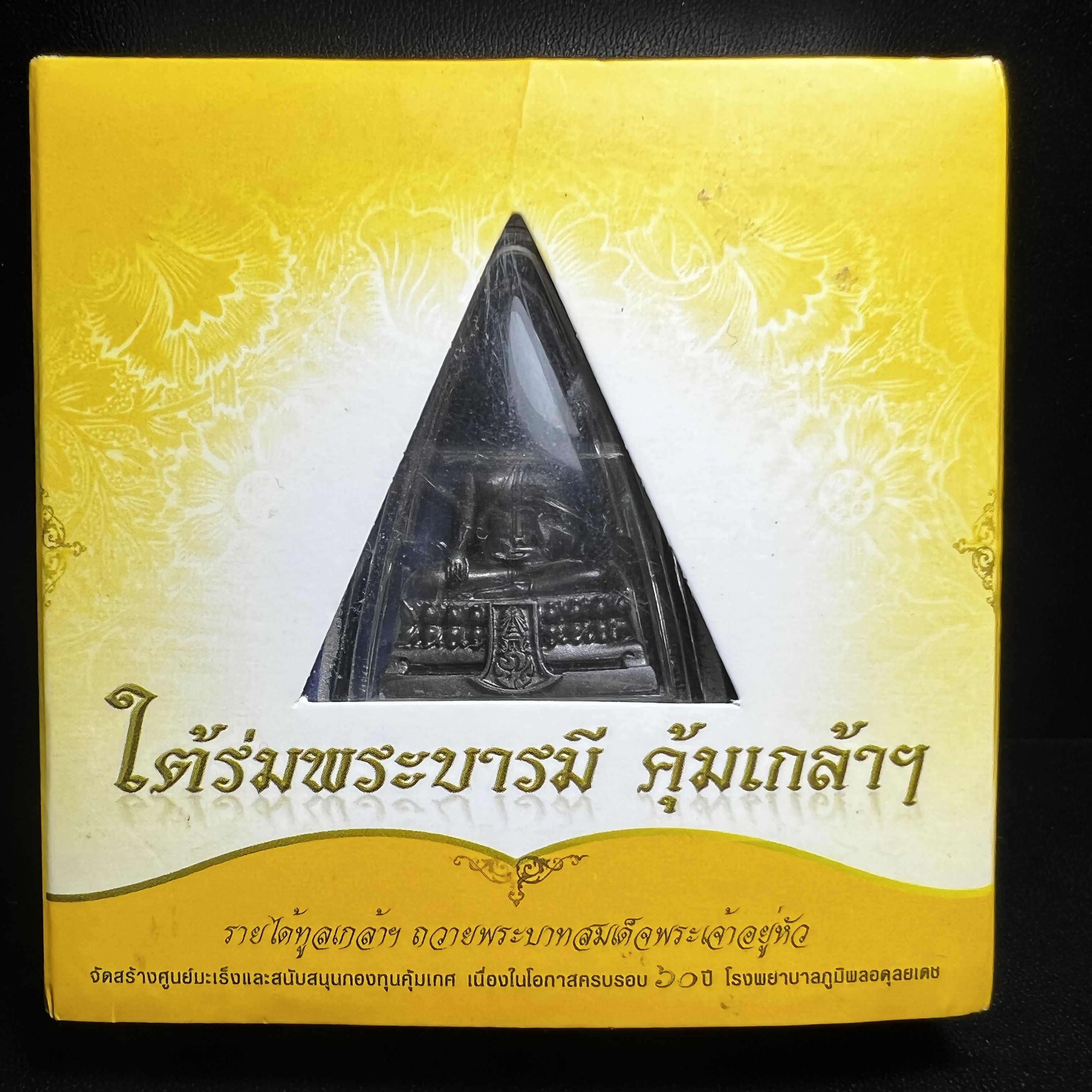 พระพุทธรูปคุ้มเกล้าฯ ภปร.(ใต้ร่มพระบารมี คุ้มเกล้า) 60ปี รพ.ภูมิพลฯ พ.ศ.2552 เนื้อนวโลหะ รมดำ(พิมพ์ใหญ่ขนาด 35.5*24 มม.)
