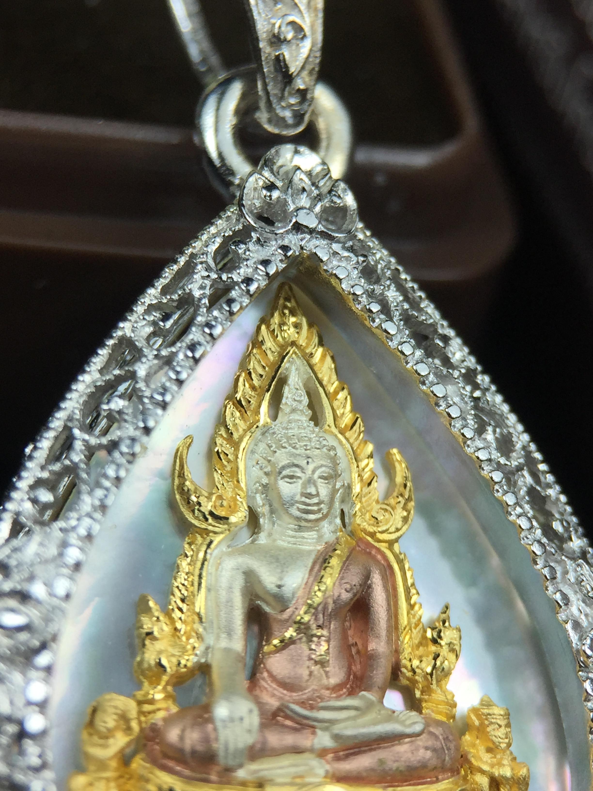 พระพุทธชินราช ภปร. โครงการ "เพราะแผ่นดินนี้ คือ แผ่นดินเกิด" ปี2548(รุ่นแรก) เหรียญทรงใบโพธิ์ ขนาด 21 x 29 มม. เนื้อเงินสามกษัตริย์ องค์พระชุบสามกษัตริย์ ล้อมด้วยกรอบเงินชุบทองคำขาวสลักเสลาเป็นลวดลายละเอียดอ่อน ส่วนพื้นองค์พระเป็นเปลือกหอยมุข