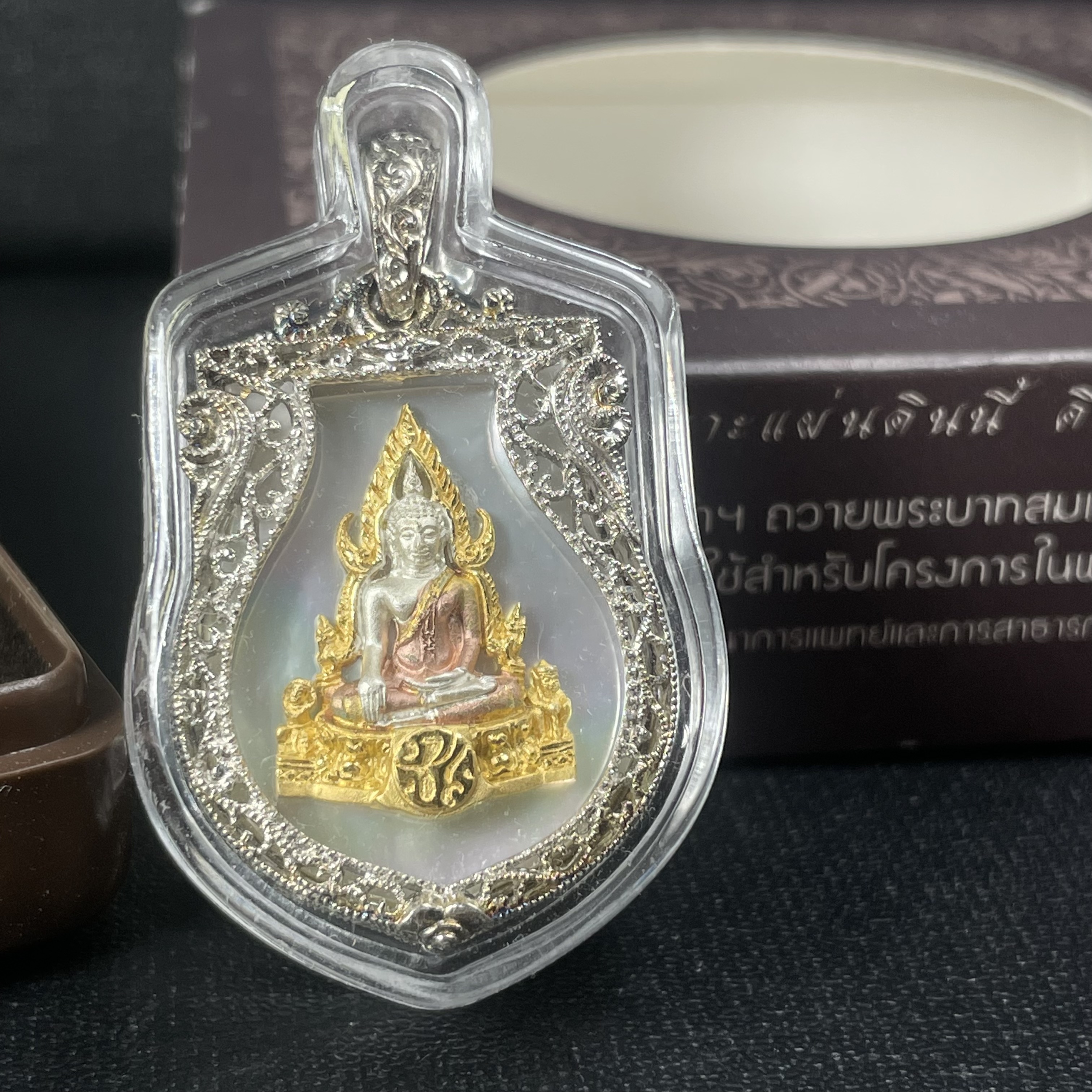 พระพุทธชินราช ภปร. โครงการ "เพราะแผ่นดินนี้ คือ แผ่นดินเกิด" ปี2548(รุ่นแรก) เหรียญทรงเสมา ขนาด 21 x 29 มม.เนื้อเงินสามกษัตริย์ องค์พระชุบสามกษัตริย์ ล้อมด้วยกรอบเงินชุบทองคำขาวสลักเสลาเป็นลวดลายละเอียดอ่อน ส่วนพื้นองค์พระเป็นเปลือกหอยมุขงดงาม