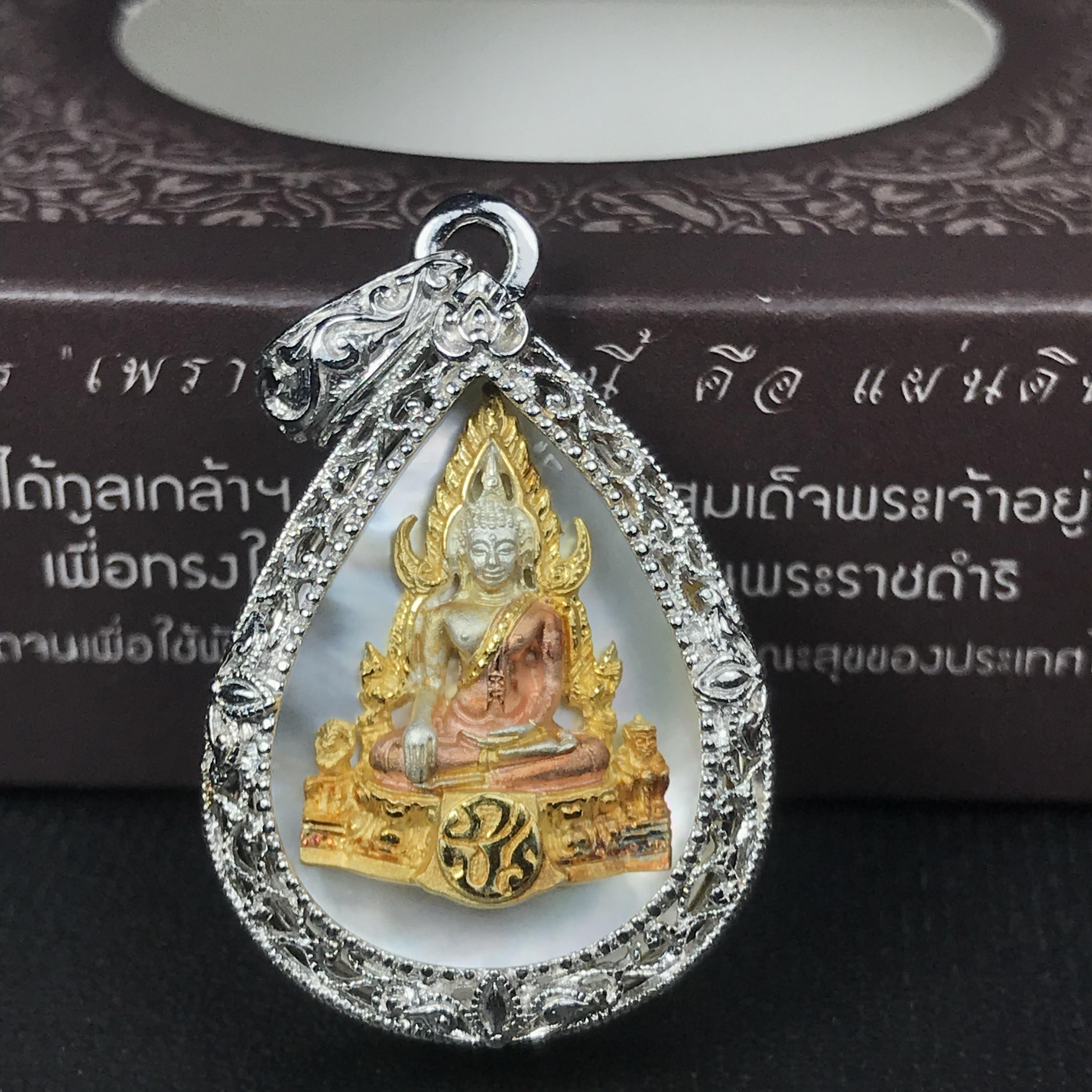 พระพุทธชินราช ภปร. โครงการ "เพราะแผ่นดินนี้ คือ แผ่นดินเกิด" ปี2548(รุ่นแรก) เหรียญทรงหยดน้ำ ขนาด 21 x 31 มม. เนื้อเงินสามกษัตริย์ องค์พระชุบสามกษัตริย์ ล้อมด้วยกรอบเงินชุบทองคำขาวสลักเสลาเป็นลวดลายละเอียดอ่อน ส่วนพื้นองค์พระเป็นเปลือกหอยมุข