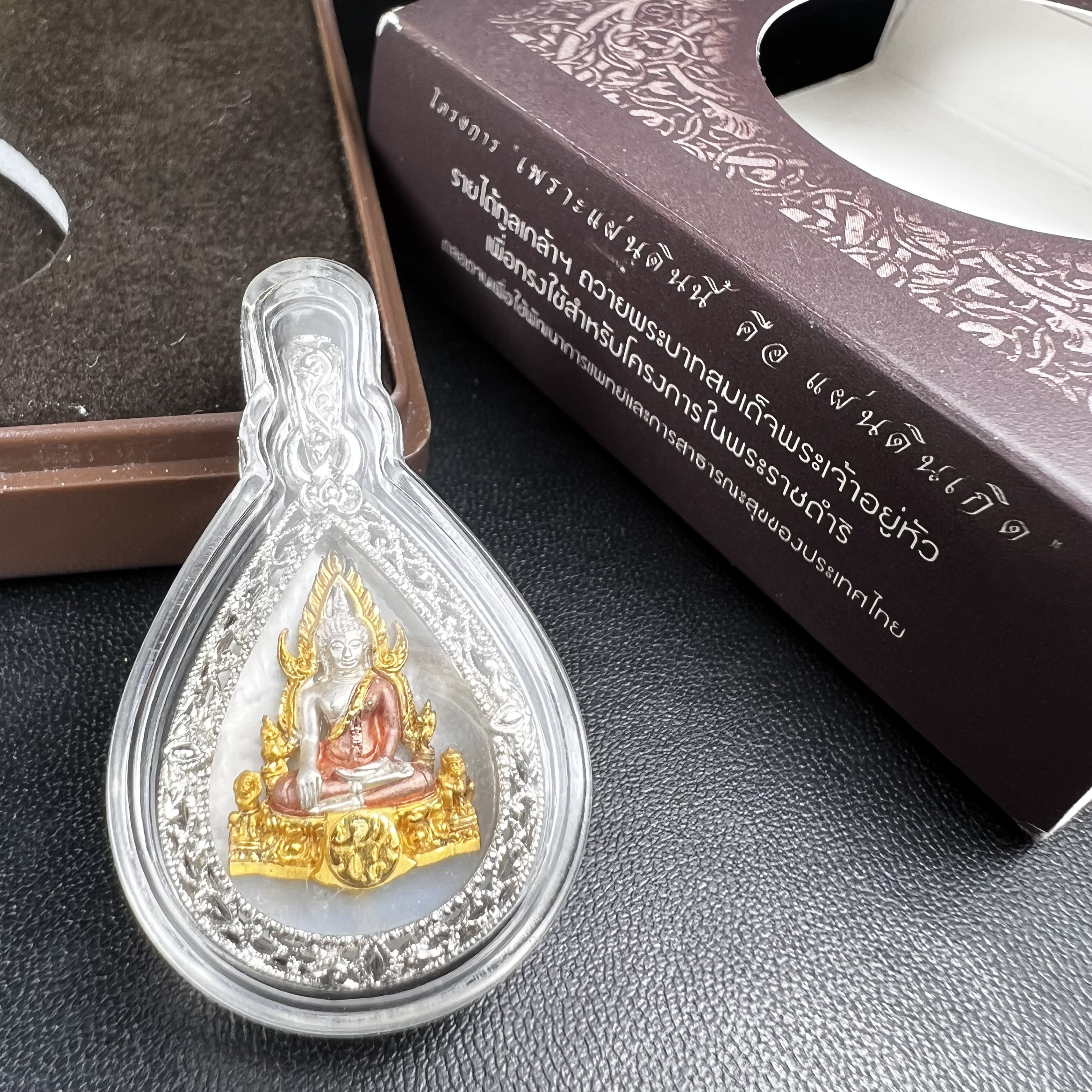 พระพุทธชินราช ภปร. โครงการ "เพราะแผ่นดินนี้ คือ แผ่นดินเกิด" ปี 2548(รุ่นแรก) เหรียญทรงหยดน้ำ ขนาด 21 x 31 มม. เนื้อเงินสามกษัตริย์ องค์พระชุบสามกษัตริย์ ล้อมด้วยกรอบเงินชุบทองคำขาวสลักเสลาเป็นลวดลายละเอียดอ่อน ส่วนพื้นองค์พระเป็นเปลือกหอยมุข