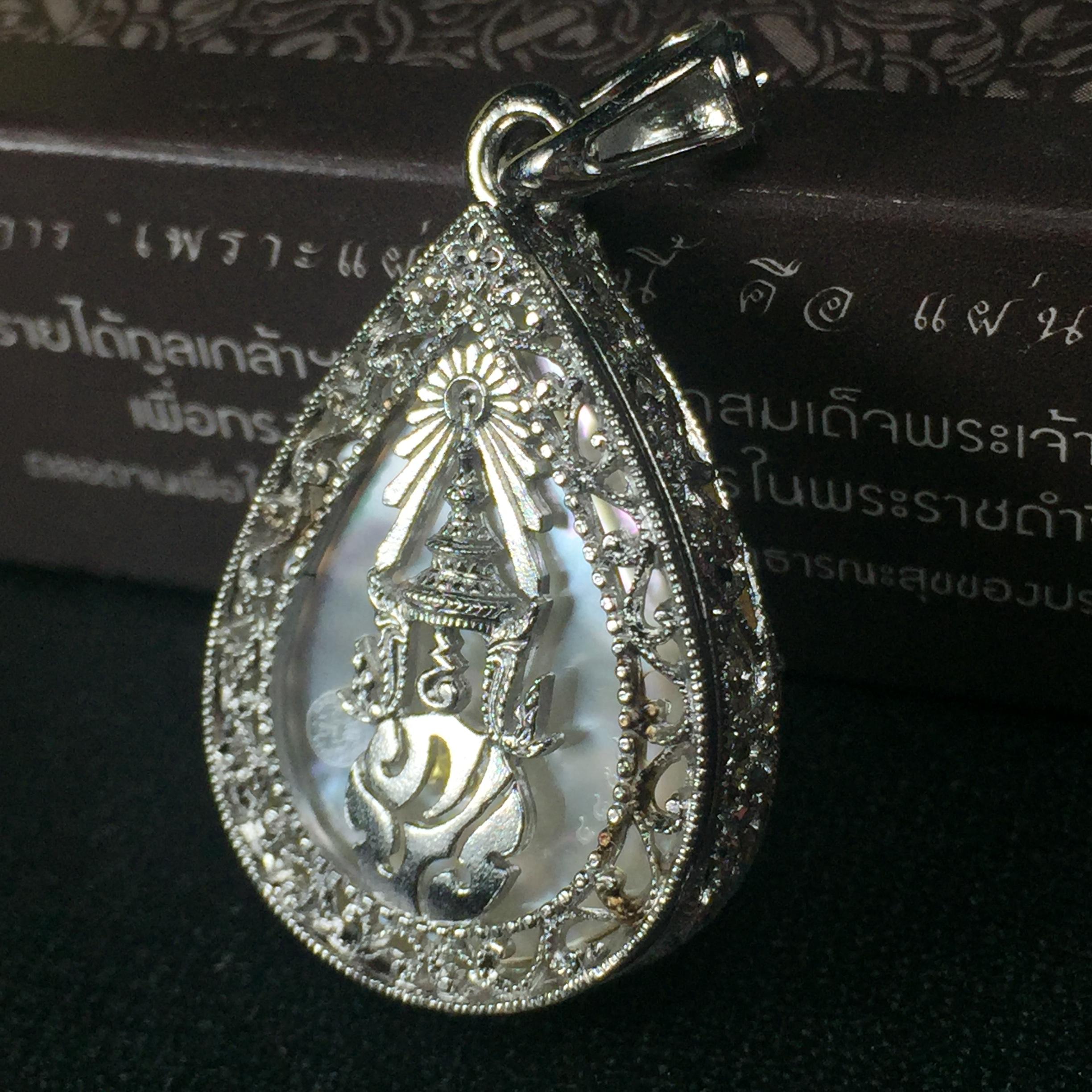 พระพุทธชินราช ภปร. โครงการ "เพราะแผ่นดินนี้ คือ แผ่นดินเกิด" ปี2548(รุ่นแรก) เหรียญทรงหยดน้ำ ขนาด 21 x 31 มม. เนื้อเงินสามกษัตริย์ องค์พระชุบสามกษัตริย์ ล้อมด้วยกรอบเงินชุบทองคำขาวสลักเสลาเป็นลวดลายละเอียดอ่อน ส่วนพื้นองค์พระเป็นเปลือกหอยมุข